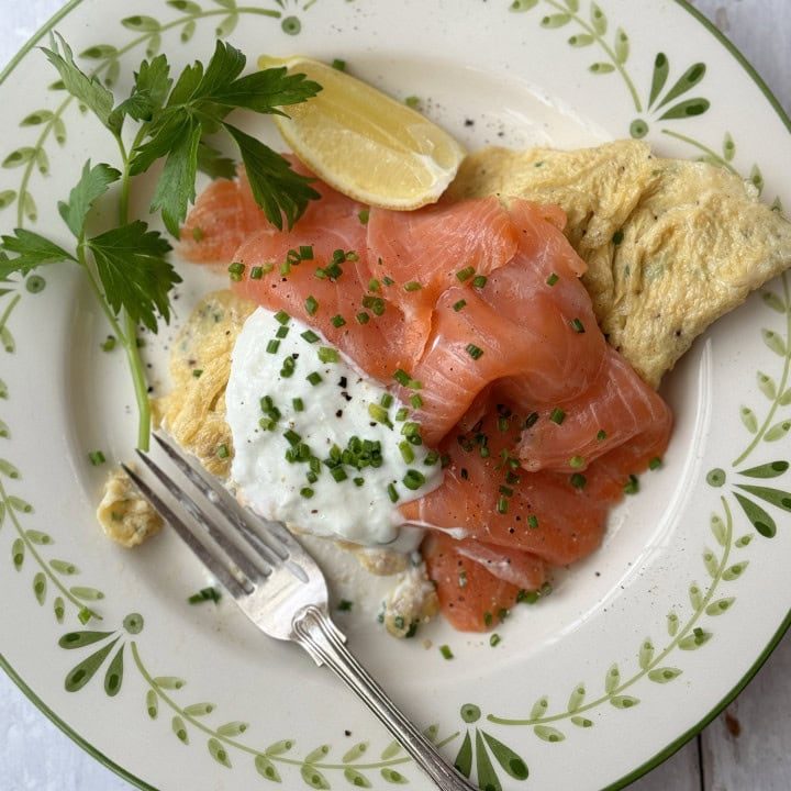 salmon omelette on white plate with fork.