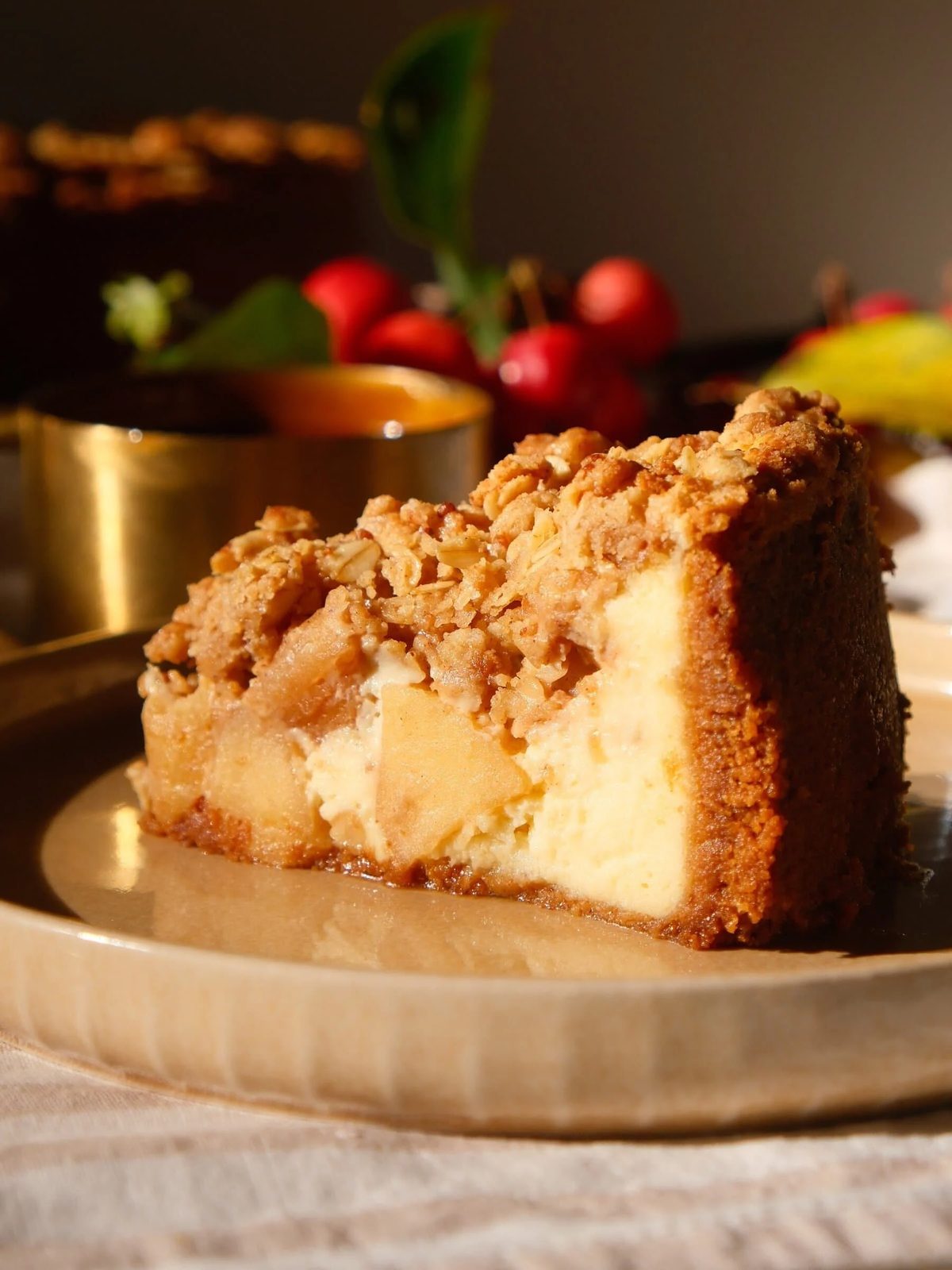 A slice of Apple Crumble Cheesecake plated on a table.