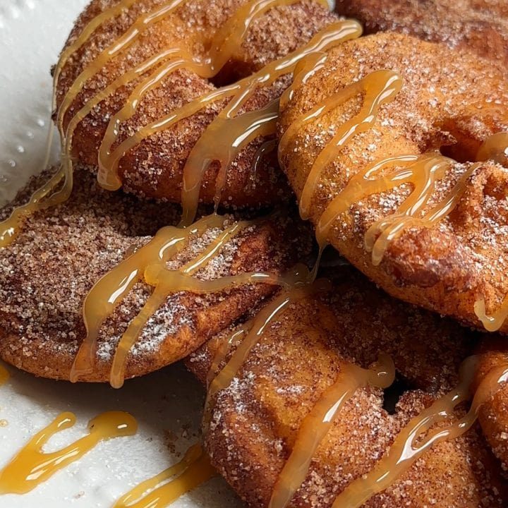 Appelflappen on a white plate with caramel sauce.