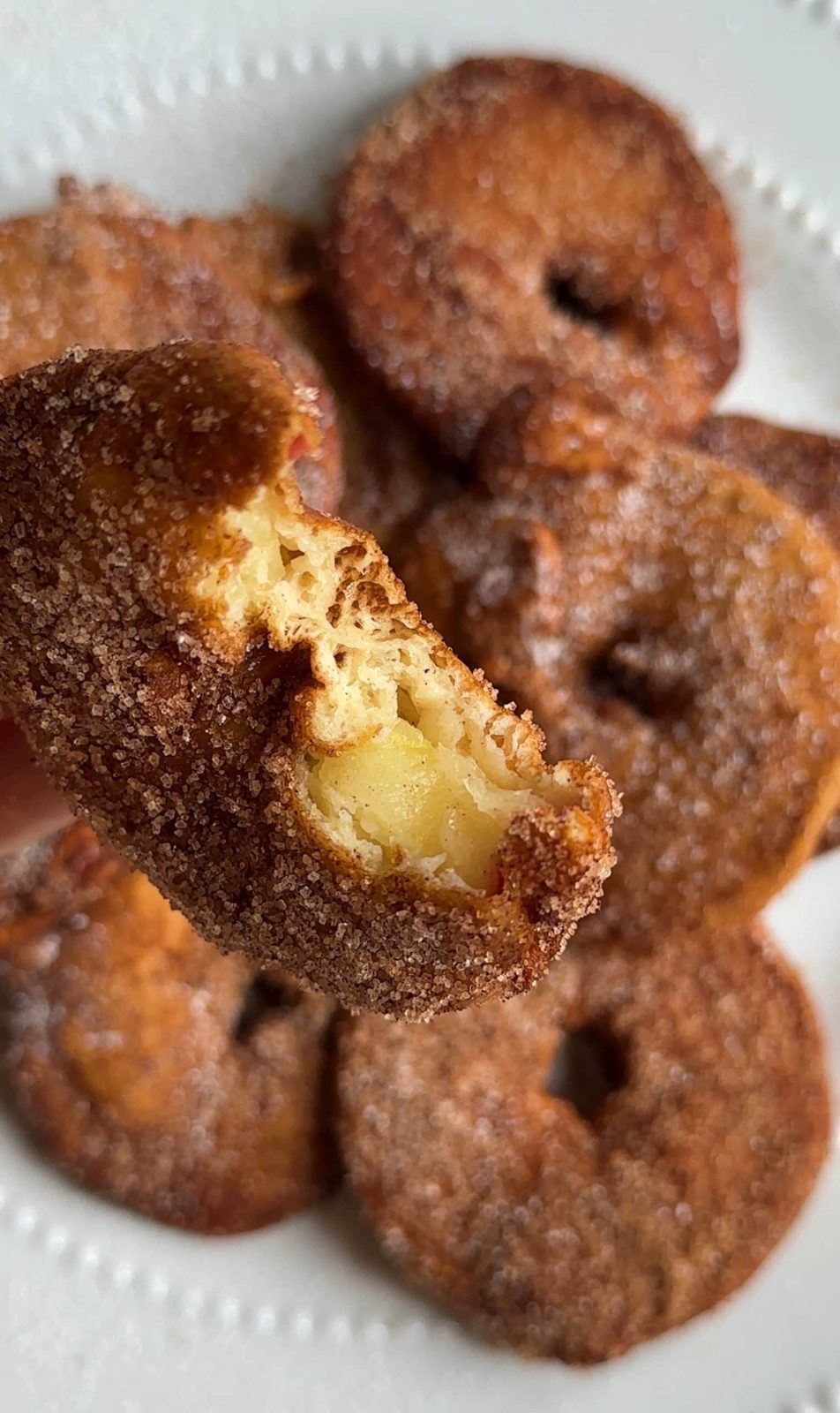 Homemade apple beignet with bite taken out.