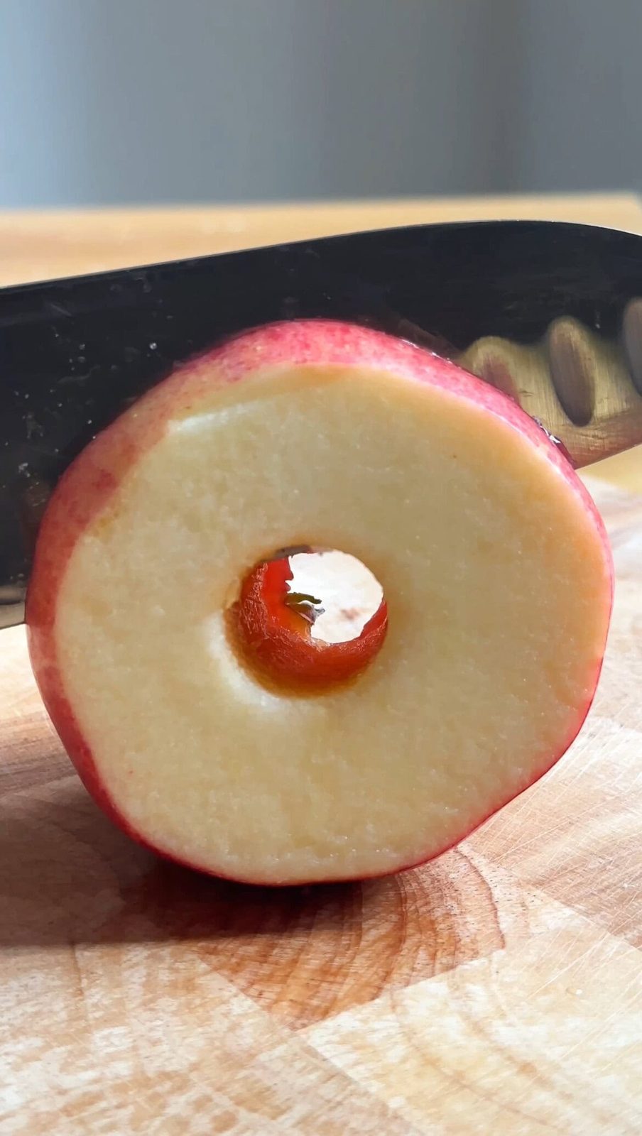 Slicing apple into rings with large knife.