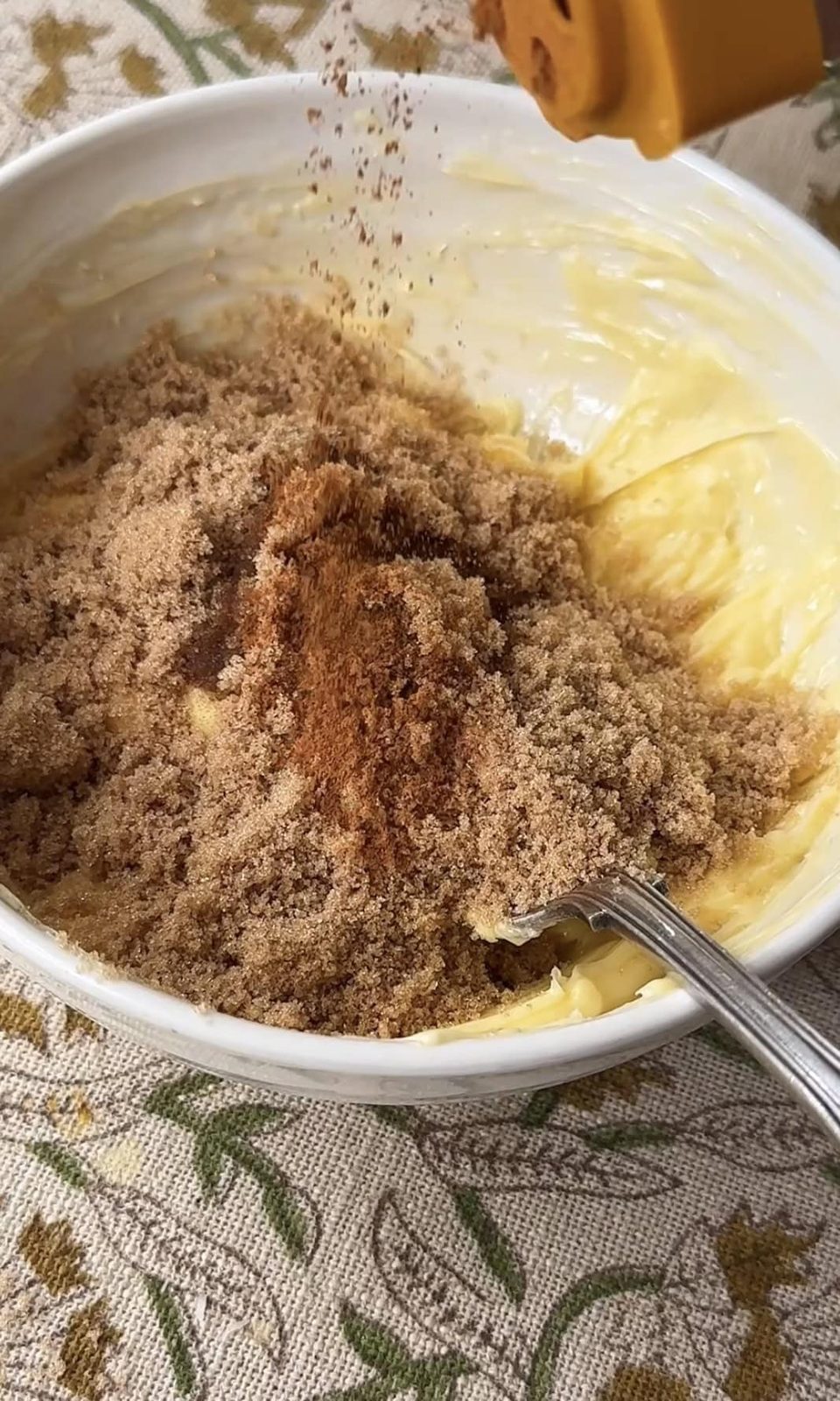 Mashing butter and sugar in bowl with spoon.