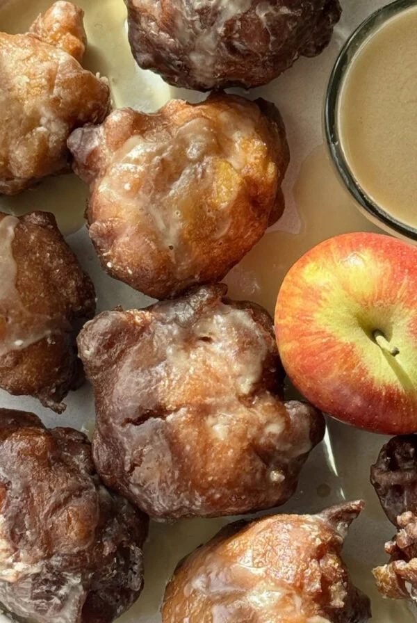 applesauce fritters on a plate with an apple.