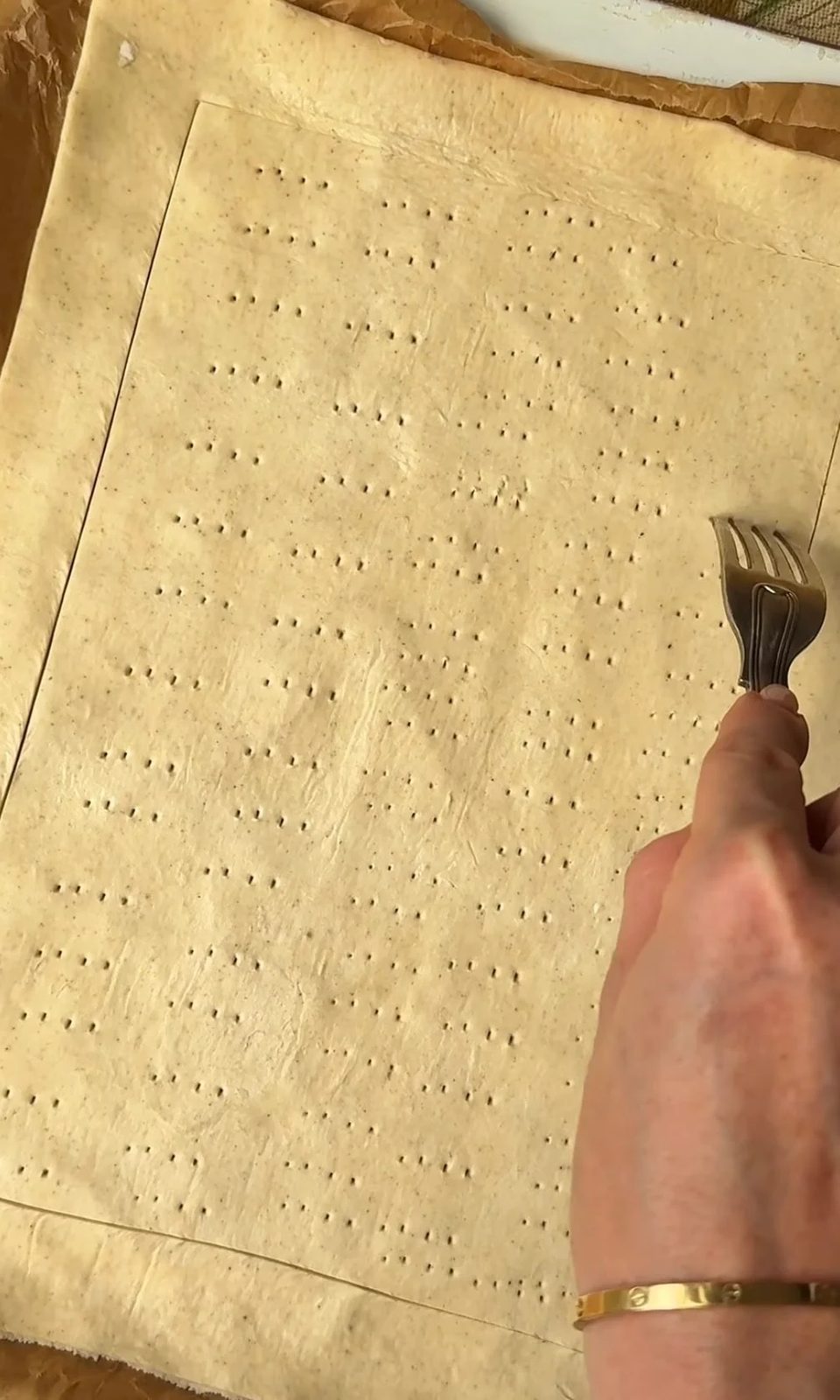 Pricking puff pastry with fork.