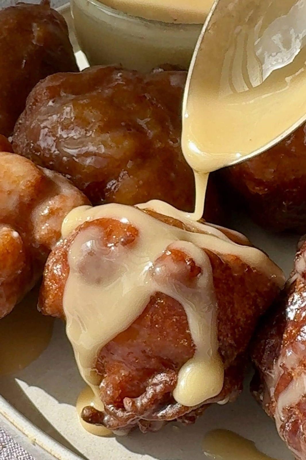 Pouring glaze over applesauce fritter.