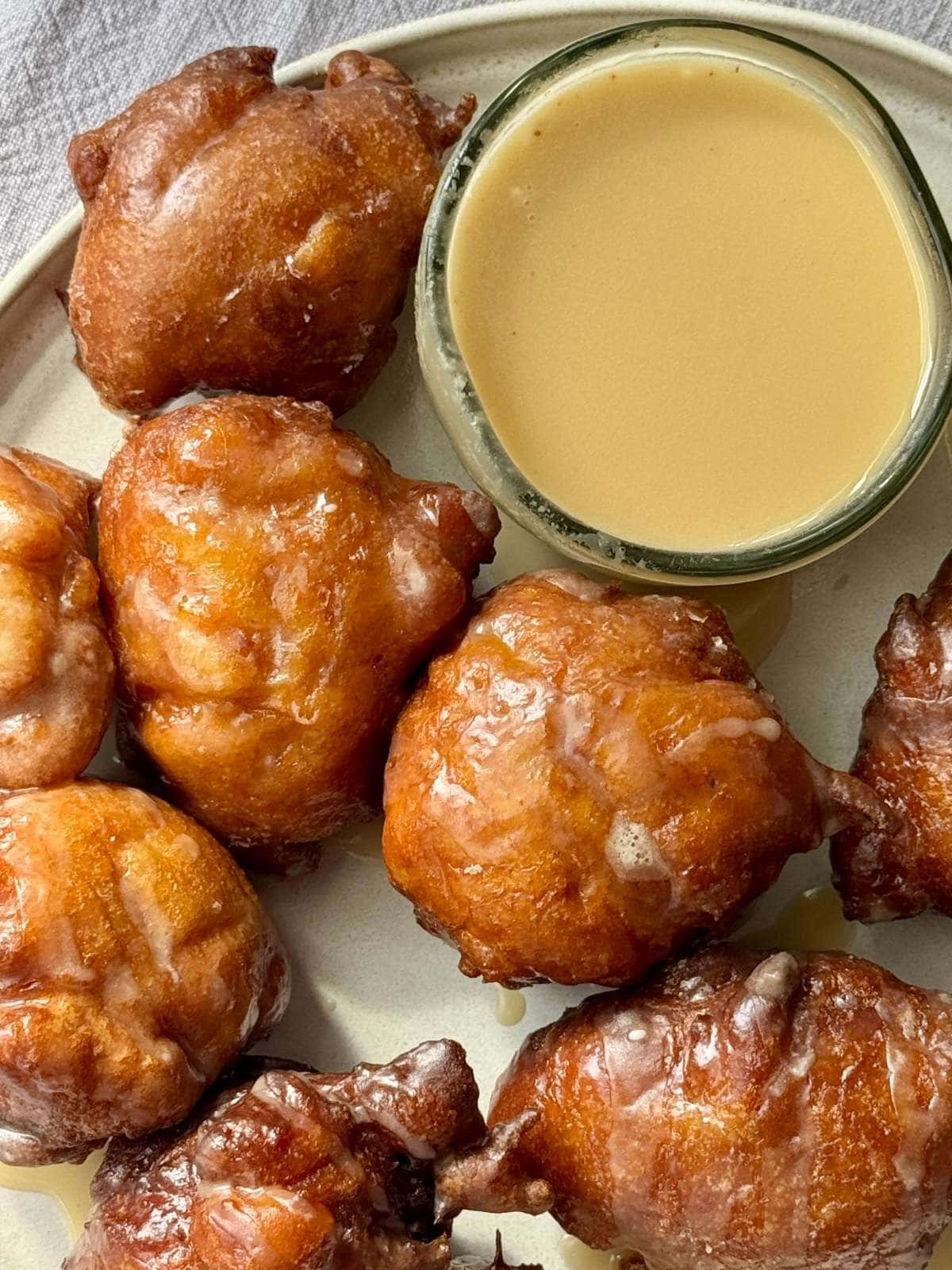 Applesauce fritters on a plate with an apple.