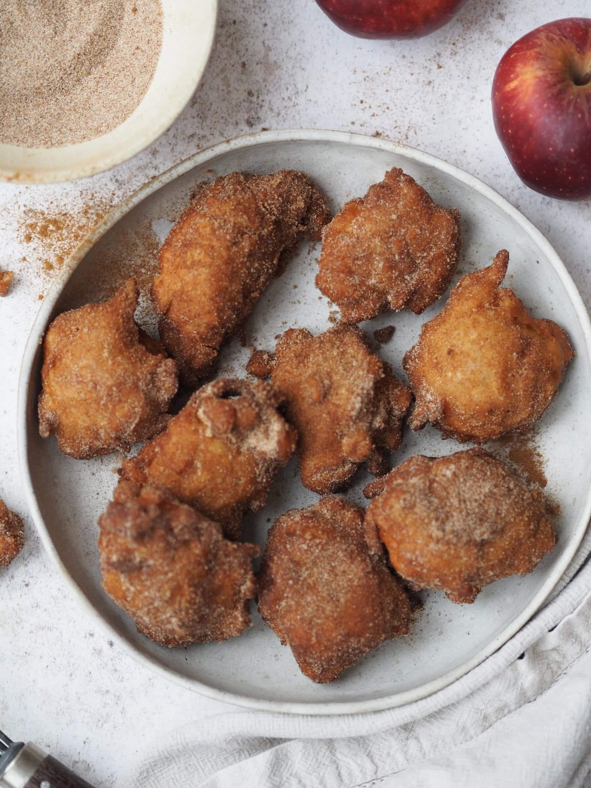 Fried applesauce fritters cooking on plate.