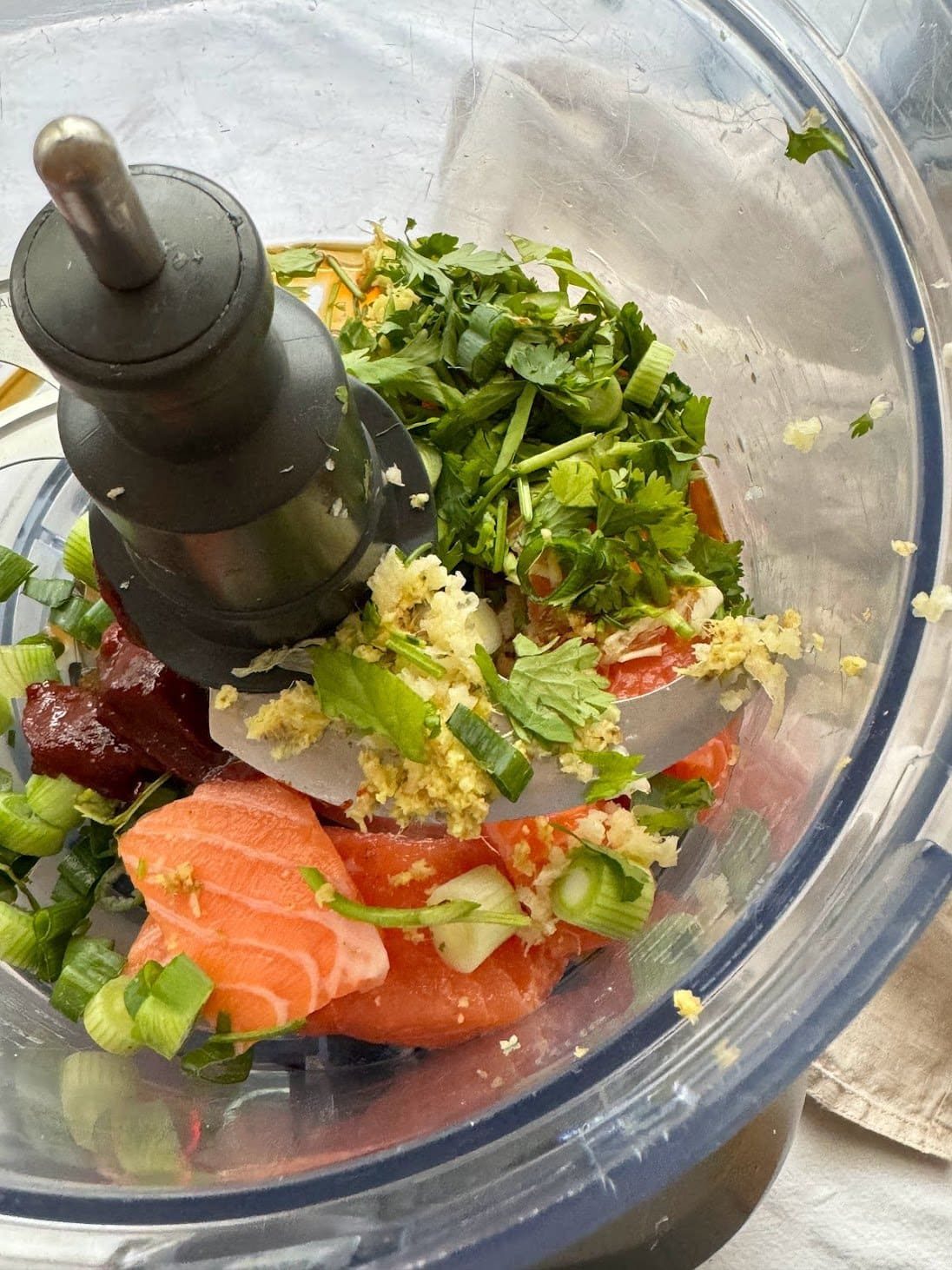 Ingredients to make Korean-inspired salmon fishcakes in the body of a food processor.
