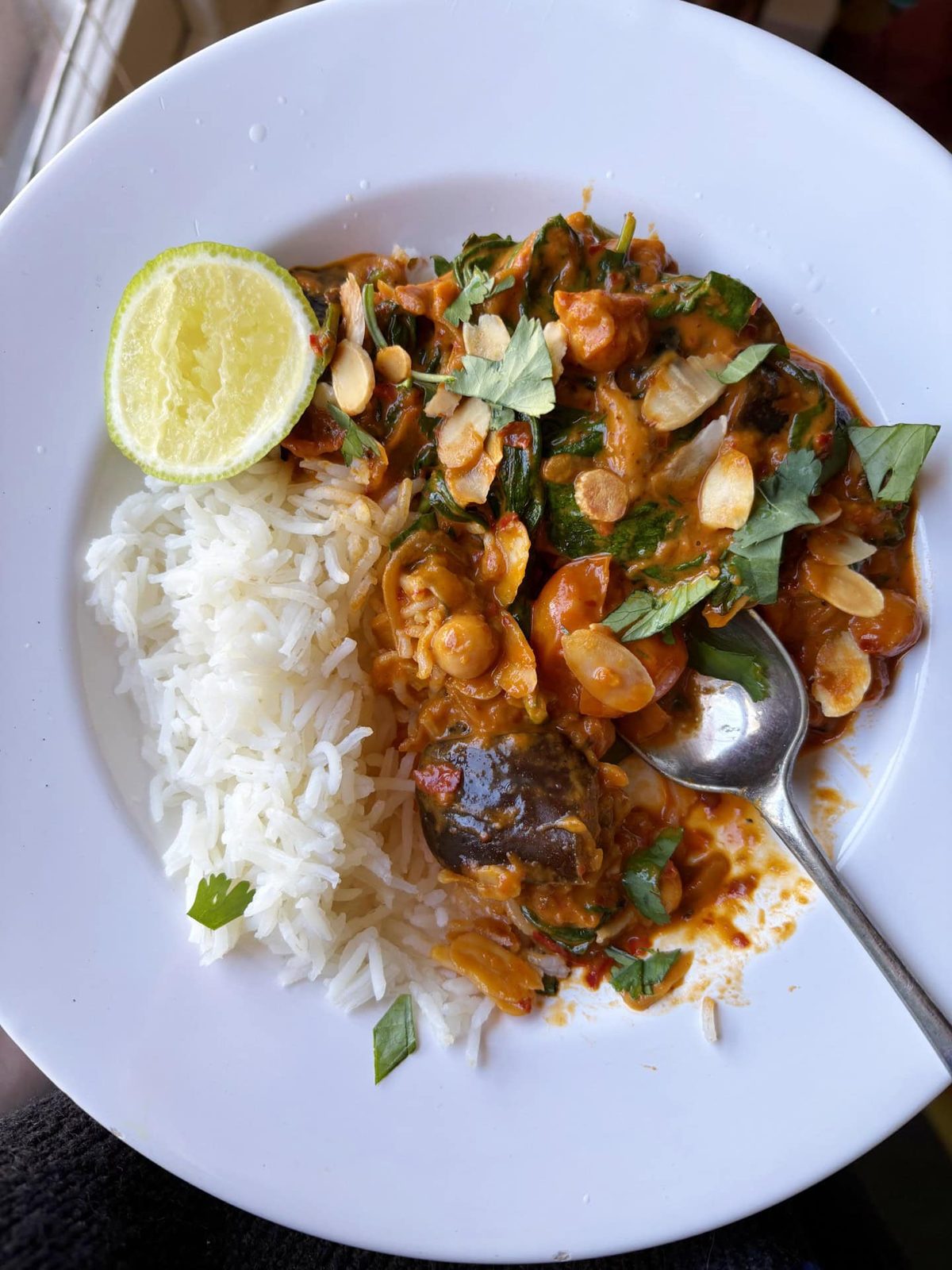 aubergine curry with rice and a wedge of lime.
