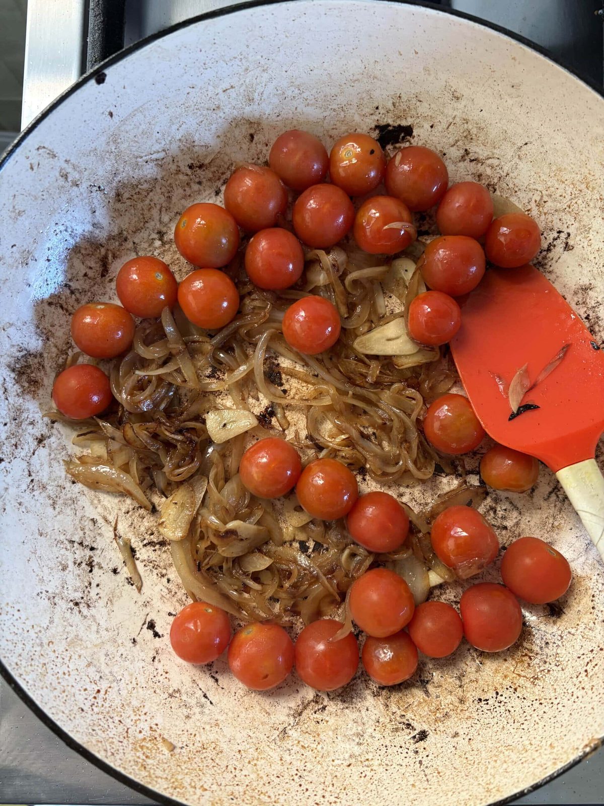adding tomatoes to onions.