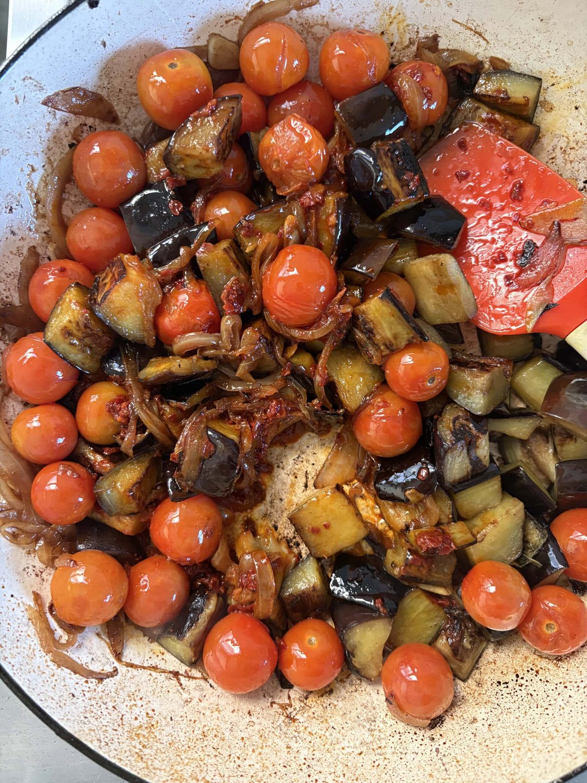 adding aubergine back to the pan.