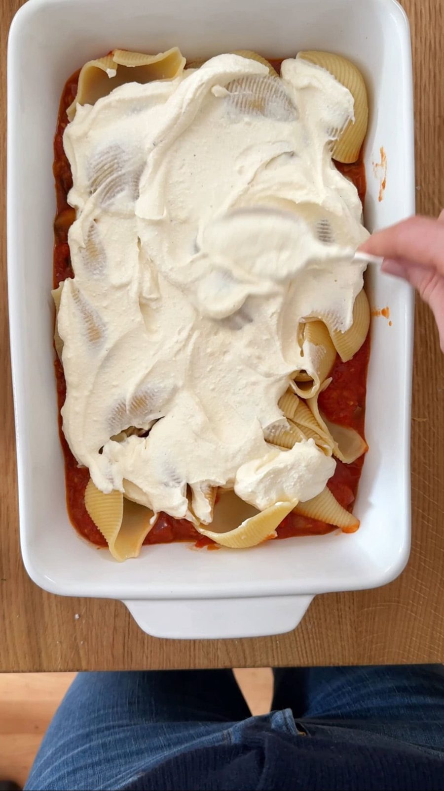 spreading creamy sauce onto the shells.