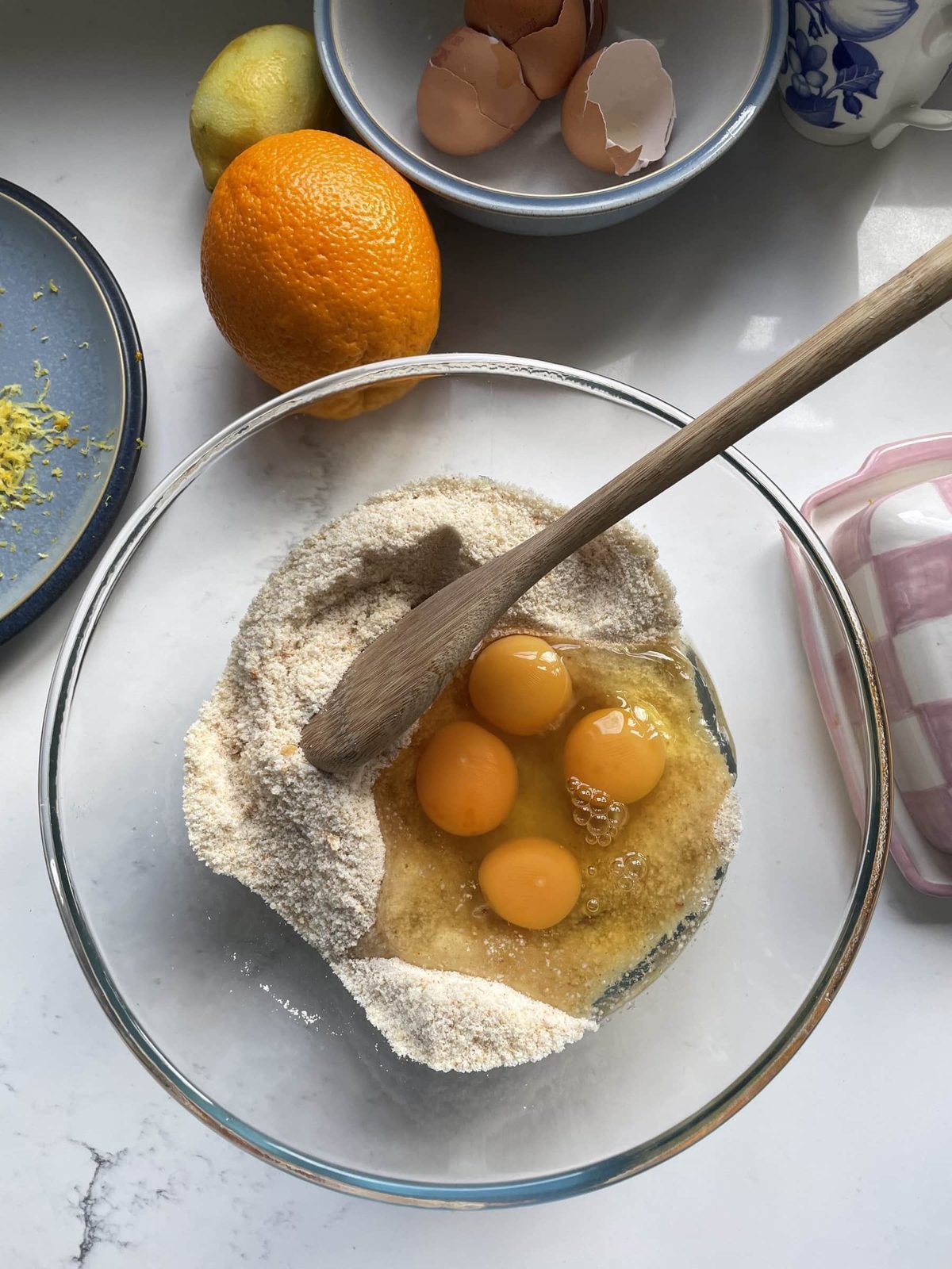 Adding eggs in the glass mixing bowl.