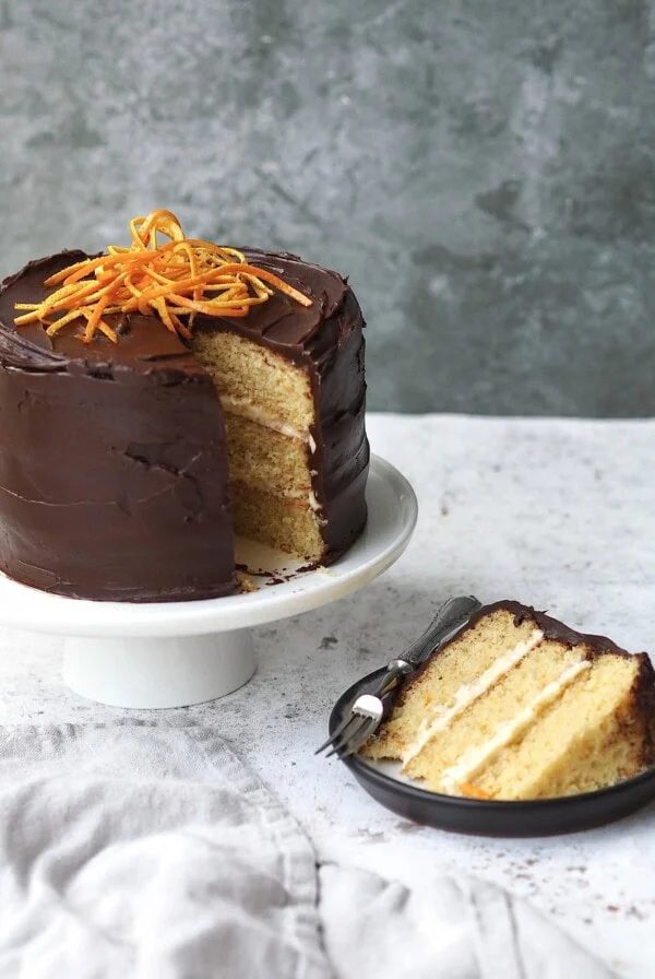 jaffa cake cake with a slice removed on a black plate