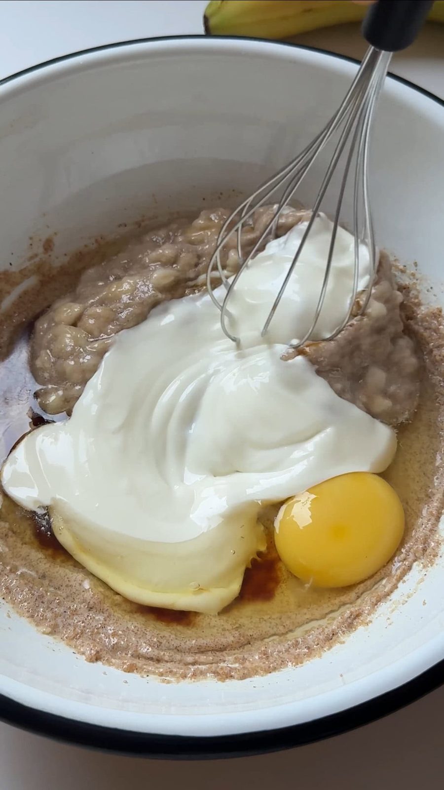 Mixing yogurt and eggs into muffin batter.