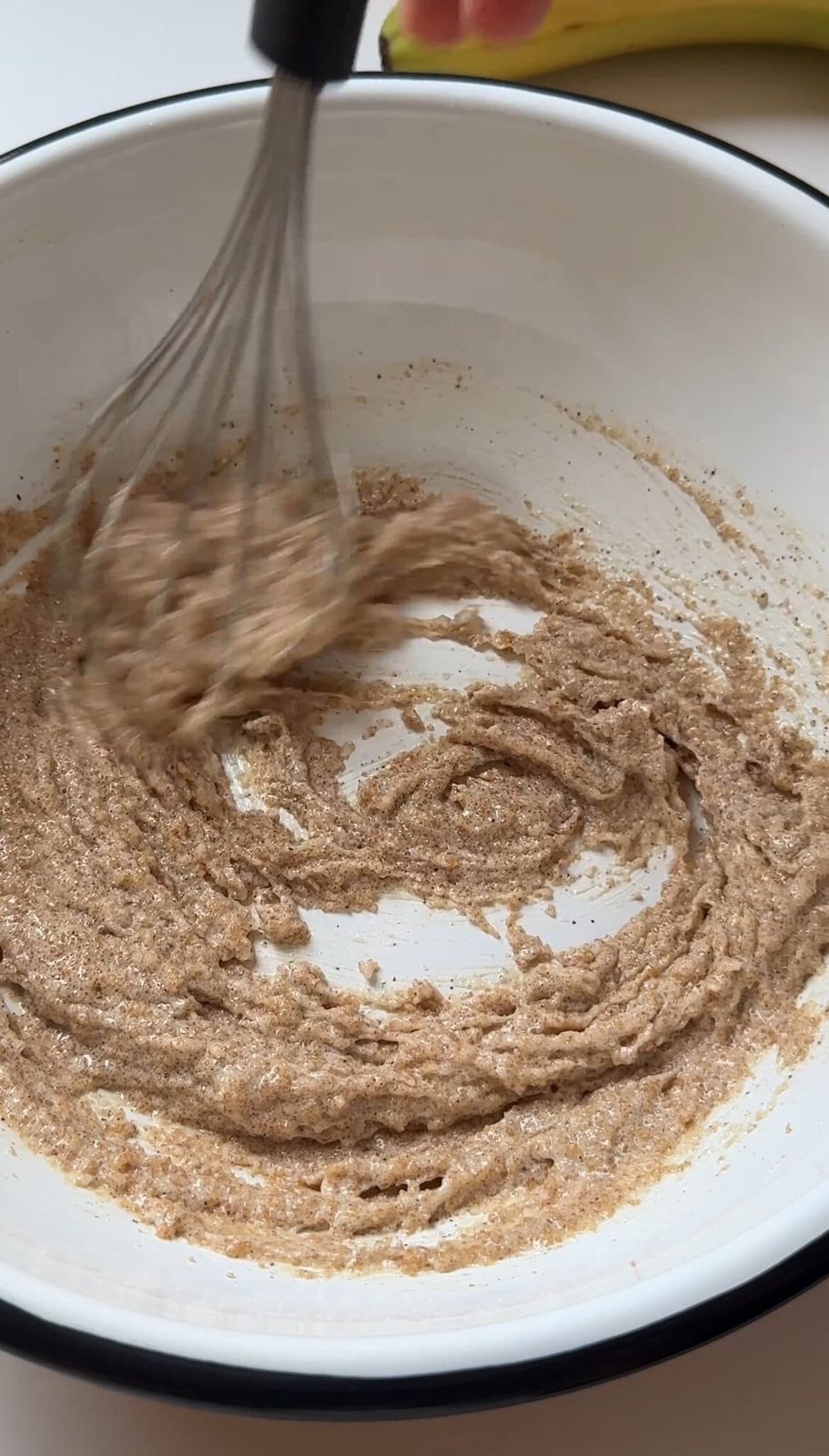 Mixing browned butter with sugar with whisk in bowl.