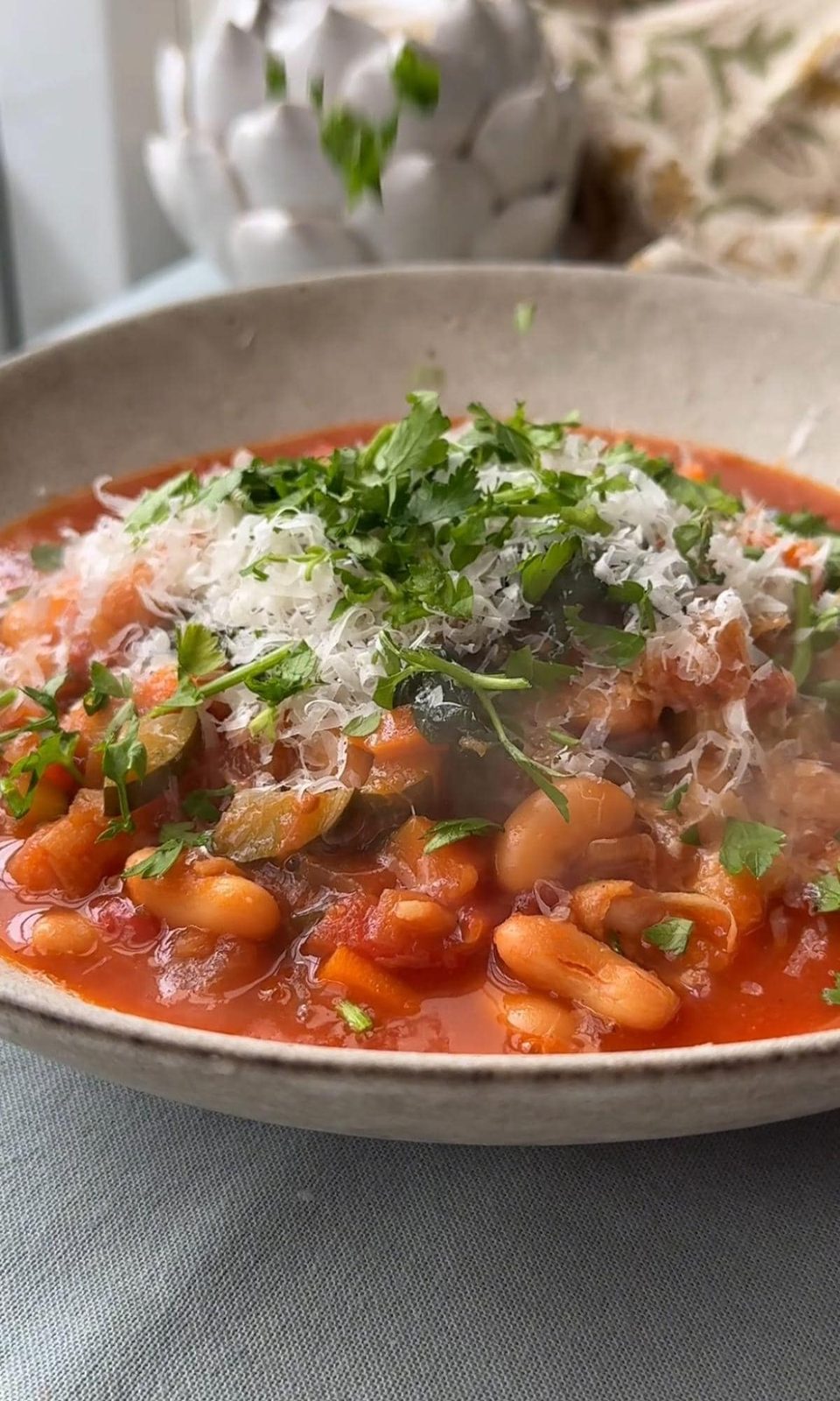 adding herbs to bean stew.