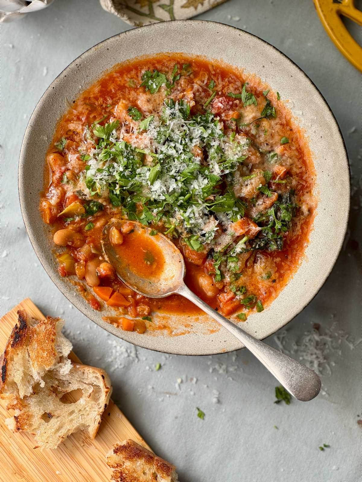 bean stew in a bowl with bread on the side.
