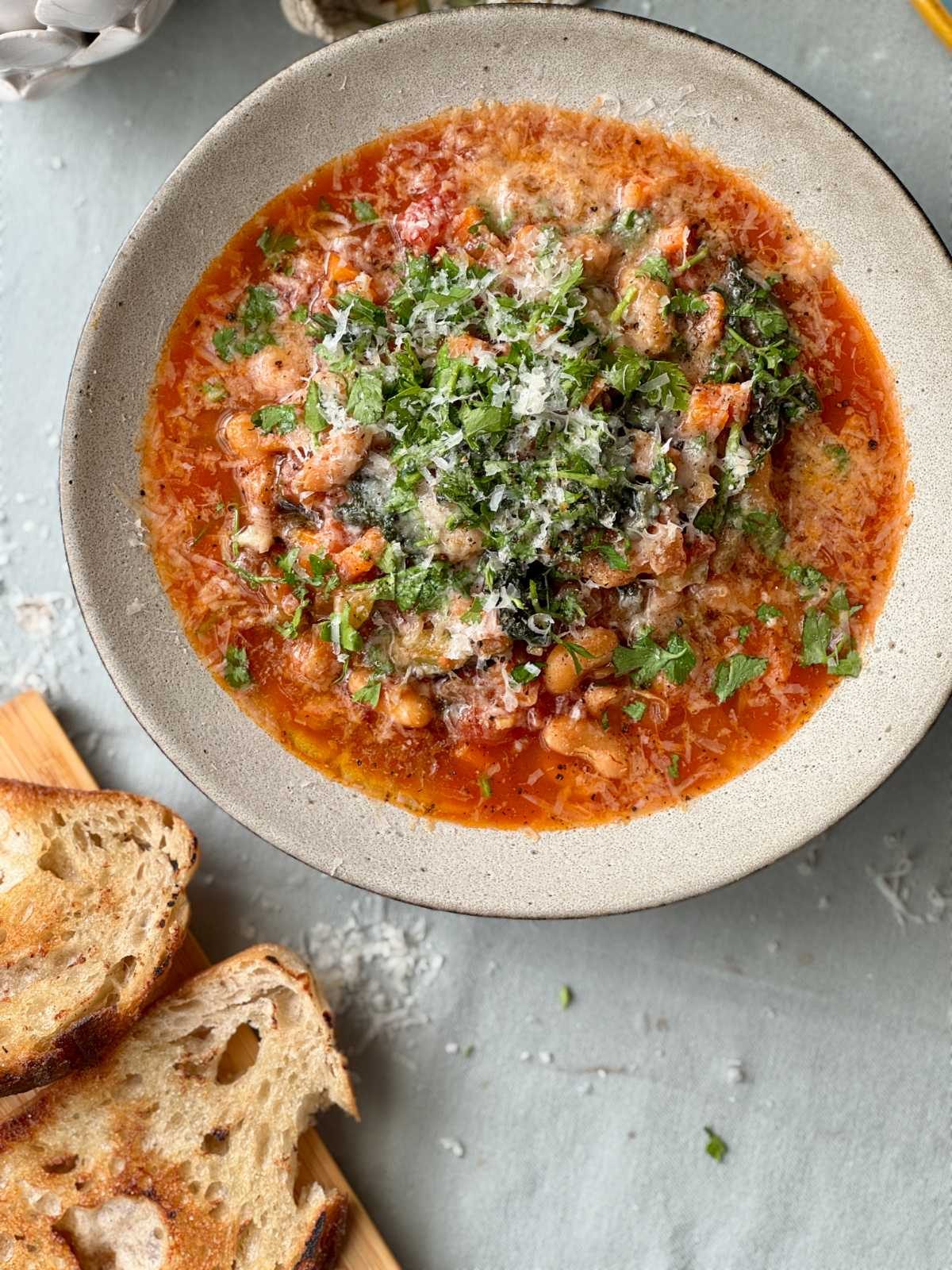 bean stew in a bowl with bread on the side.