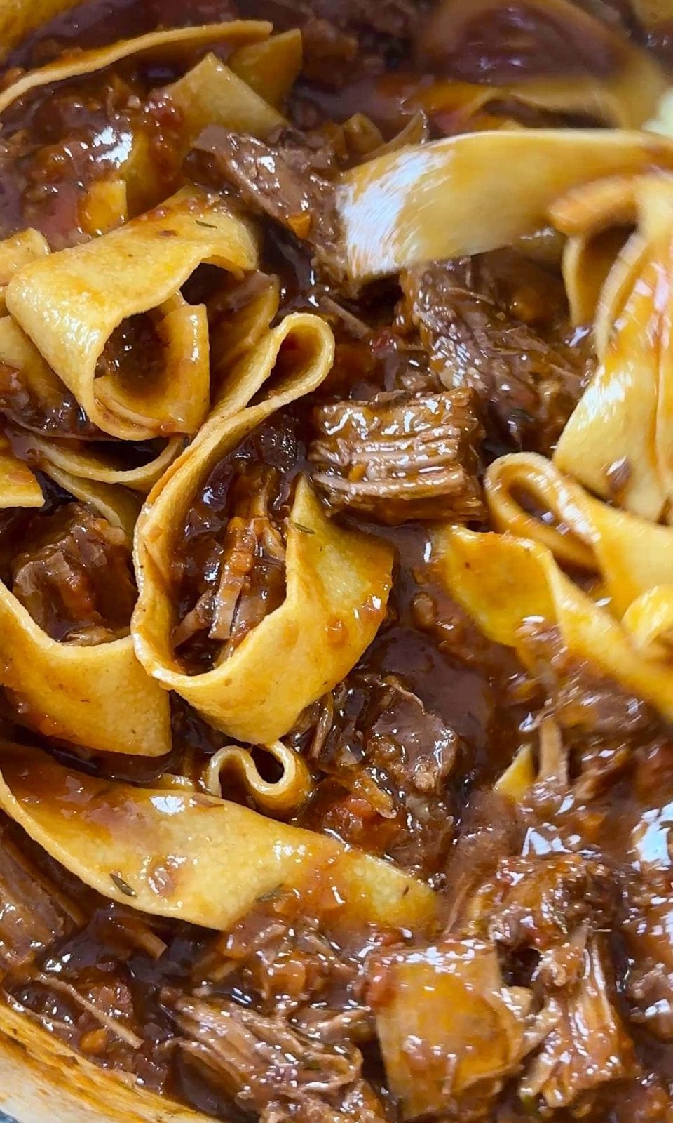 Tossing pappardelle with beef short ribs ragu sauce