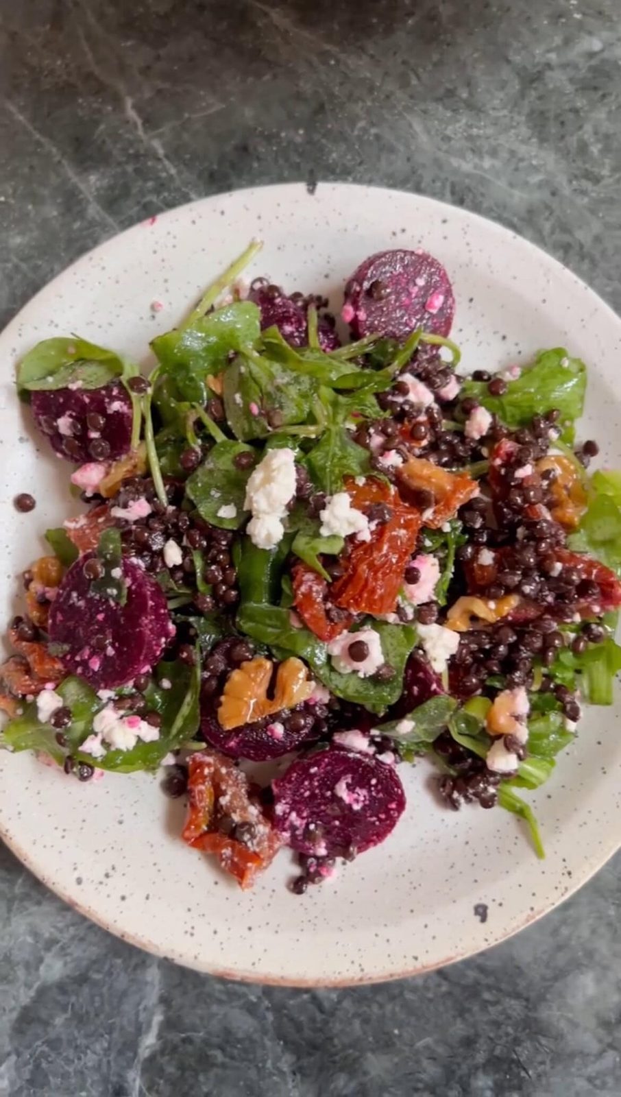 Beetroot salad with feta, arugula, and walnuts in a bowl
