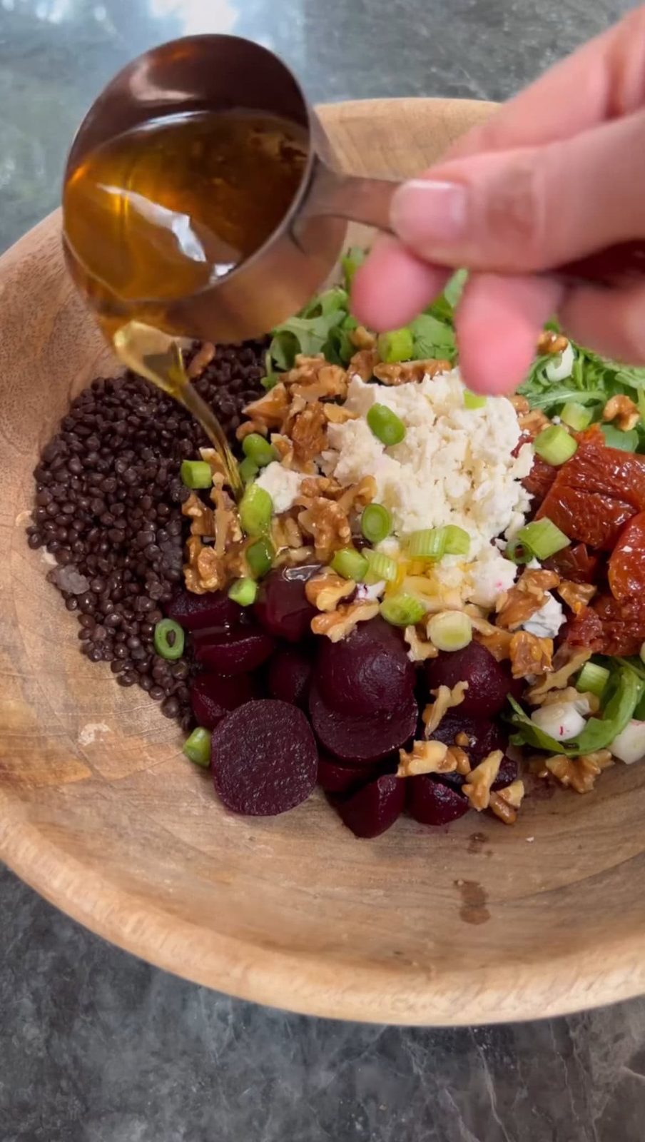 Drizzling sun-dried tomato oil over beetroot and feta salad.