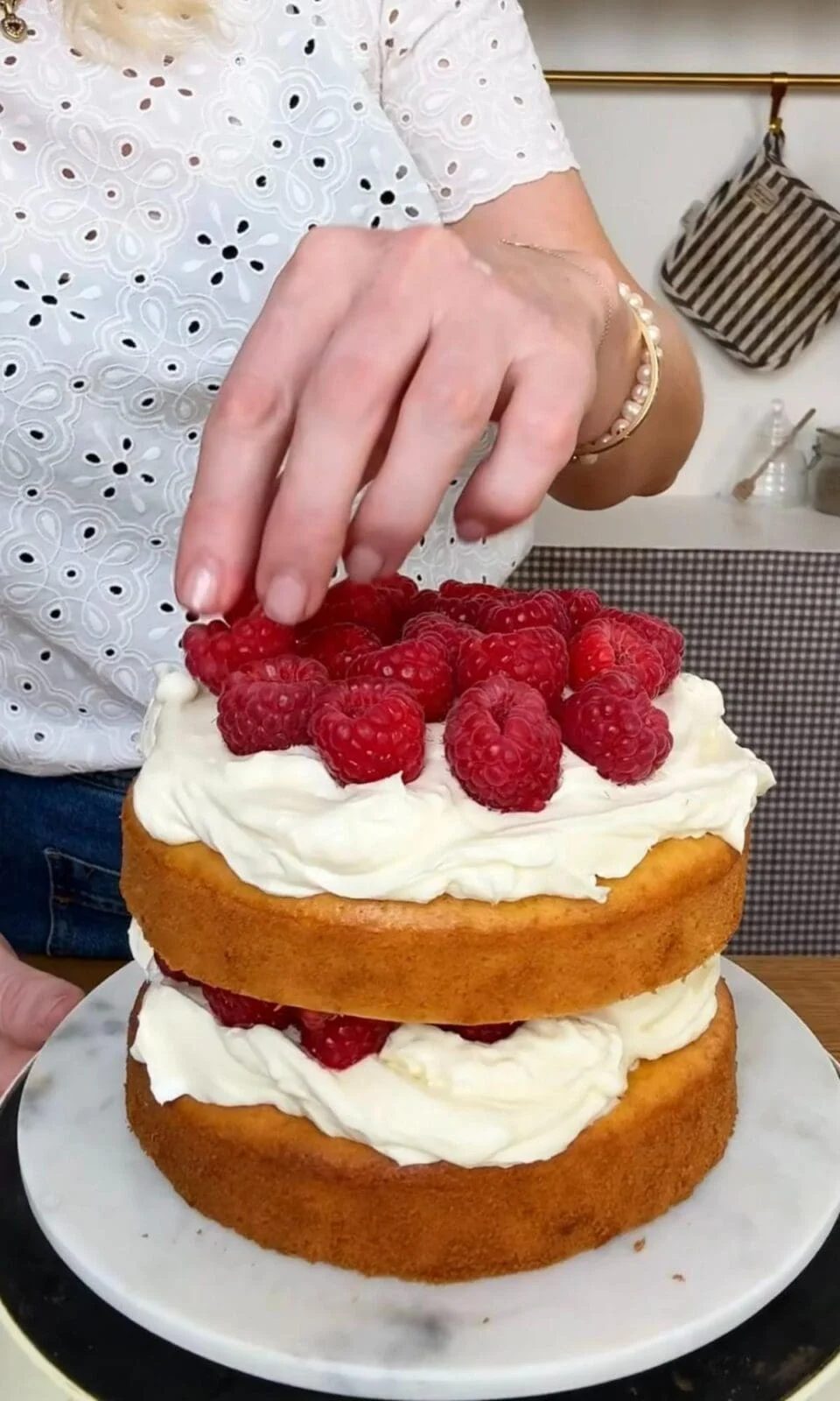 adding berries to the top of the berry cake.