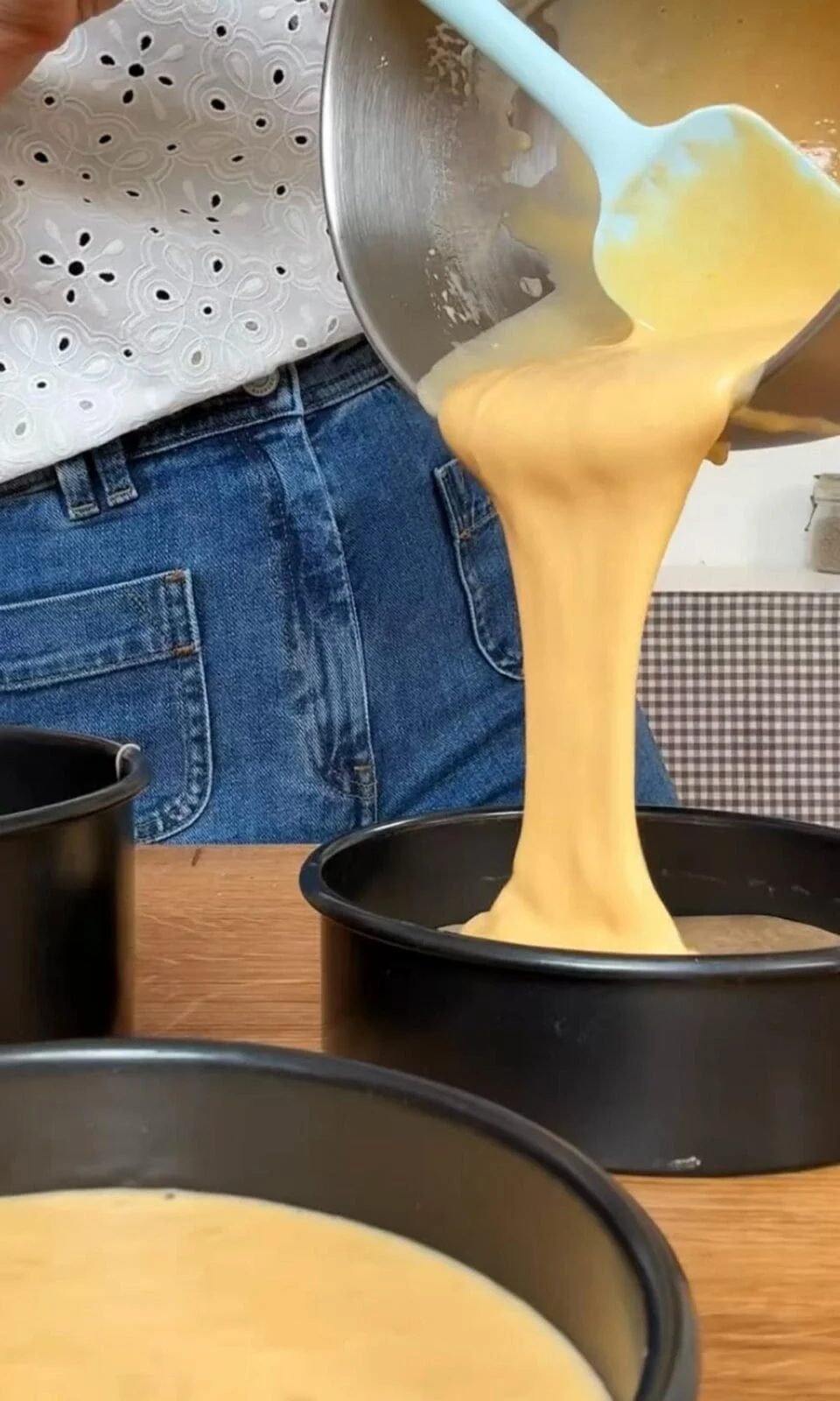 separating cake batter into tins.