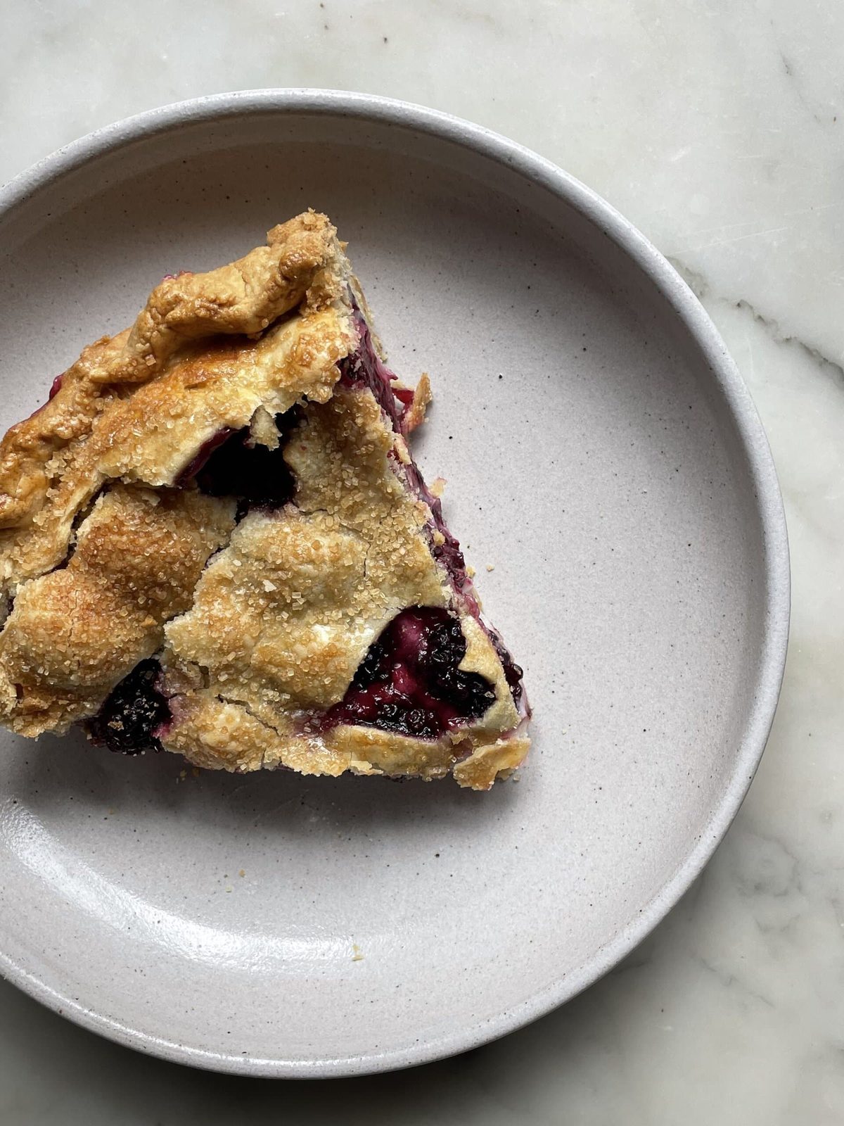 Slice of blackberry cream cheese pie on plate.