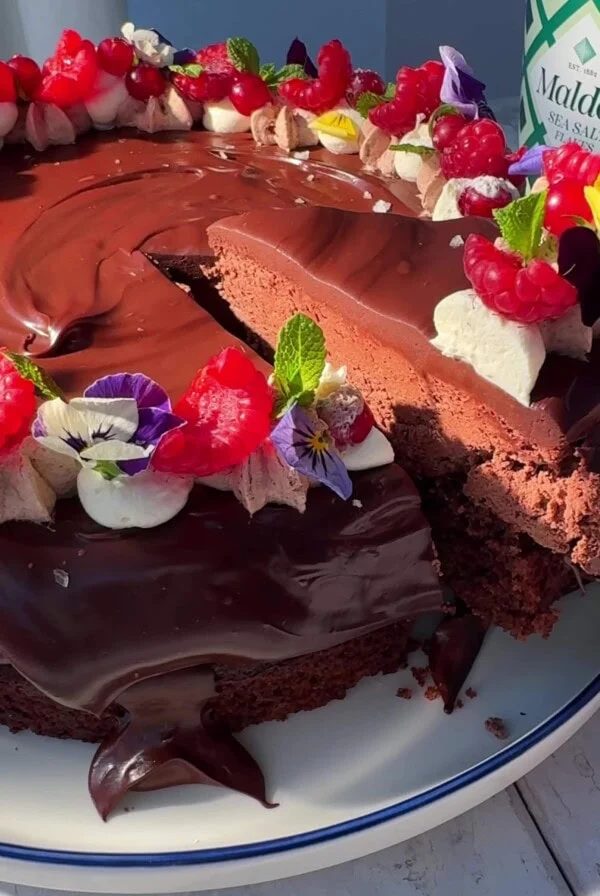 chocolate cake with chocolate mousse with slice removed.