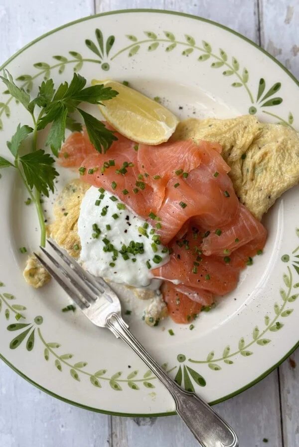 salmon omelette on white plate with fork.