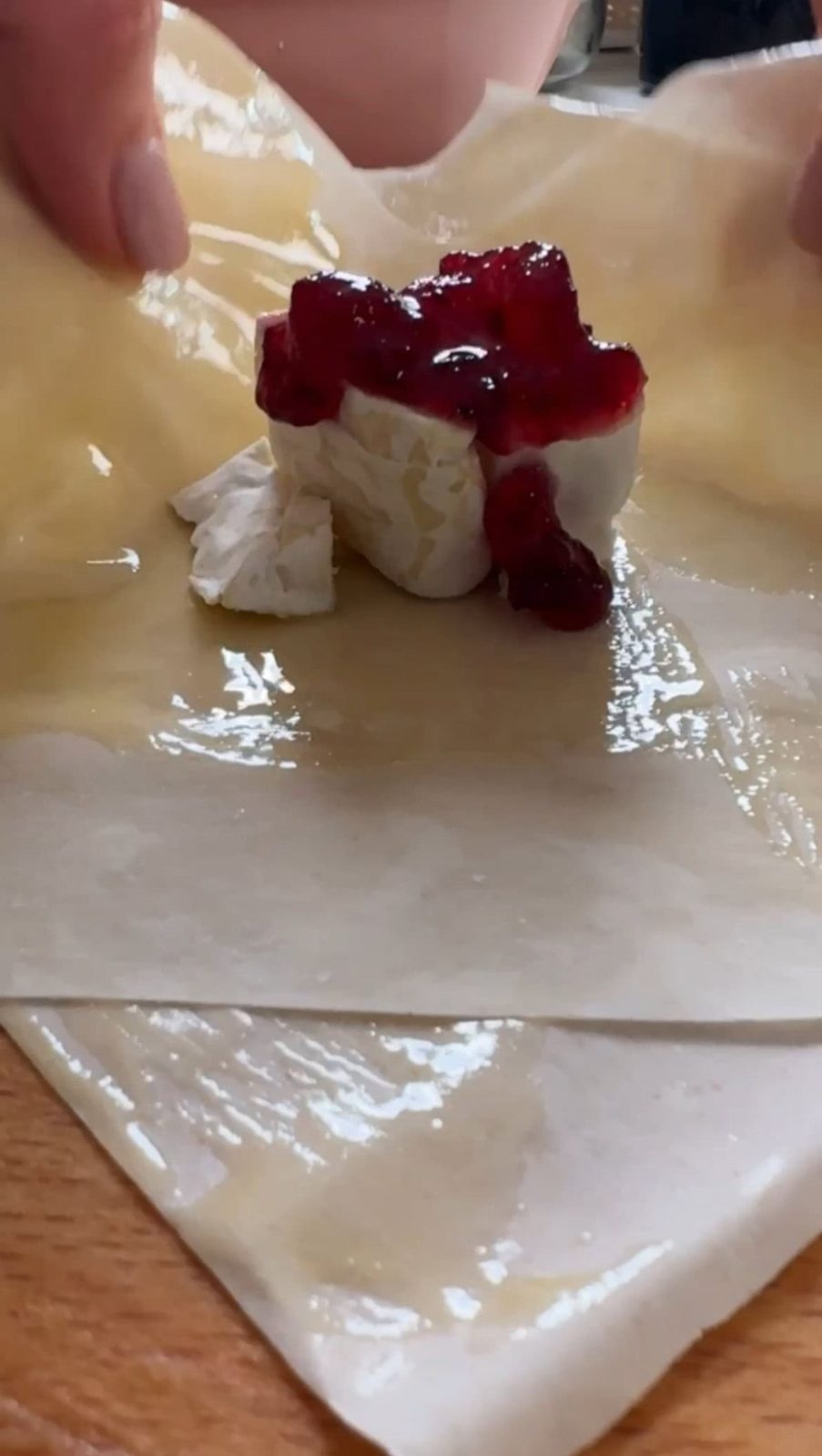 Wrapping Brie with cranberry sauce in filo sheets.