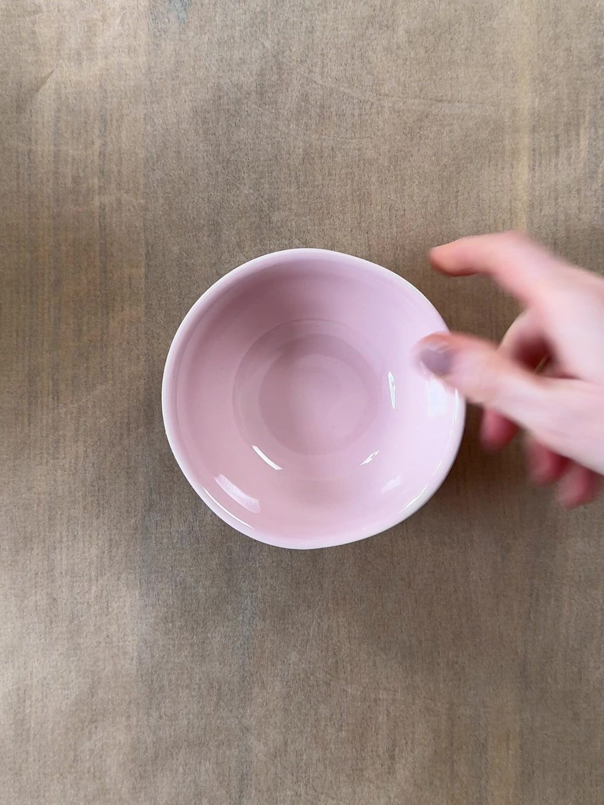 Placing a pink ramekin on parchment paper.
