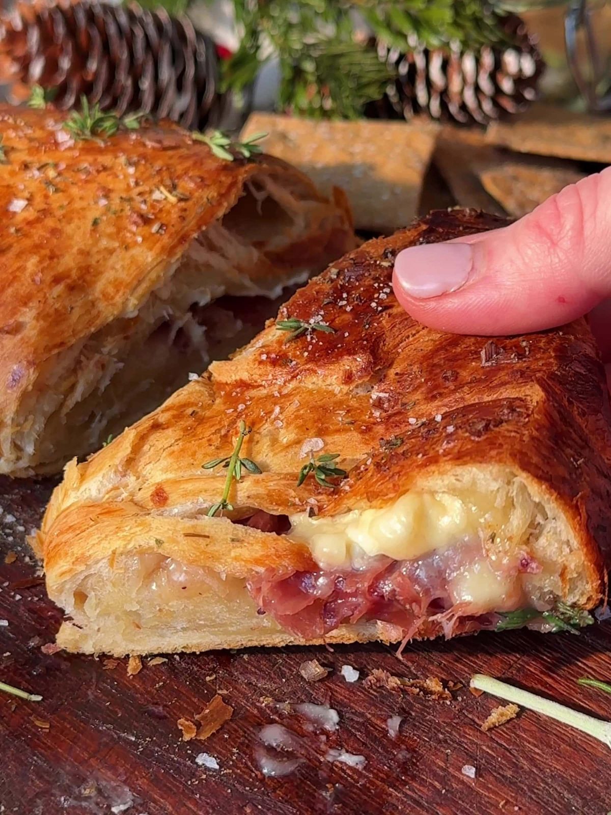 Holding a slice of Bacon Brie Crescent Wreath.