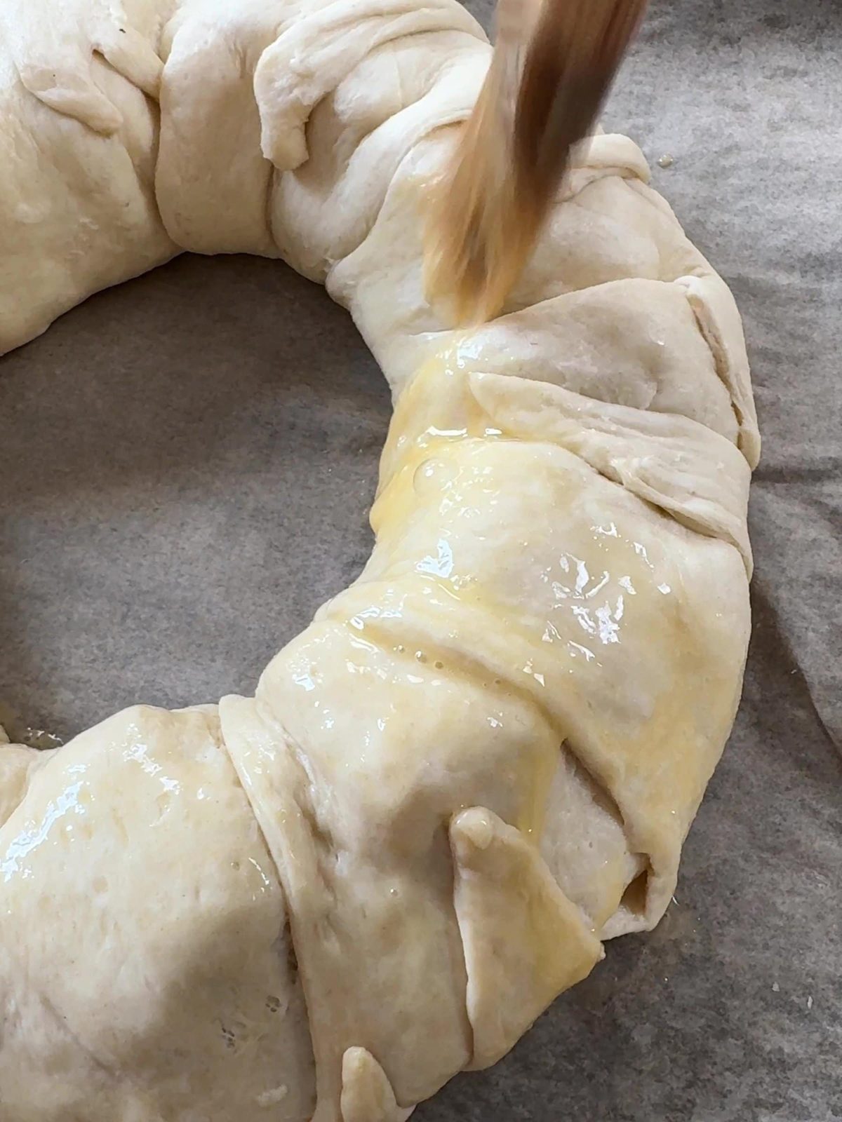 Brushing the Brie Crescent Wreath with egg.