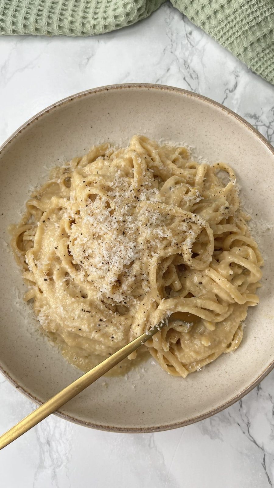 Brown Butter Pasta with Caramelised Onions with a fork in the pasta in a beige bowl