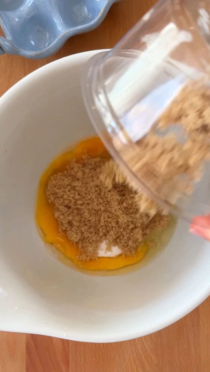 Adding brown sugar to eggs for brownie batter.