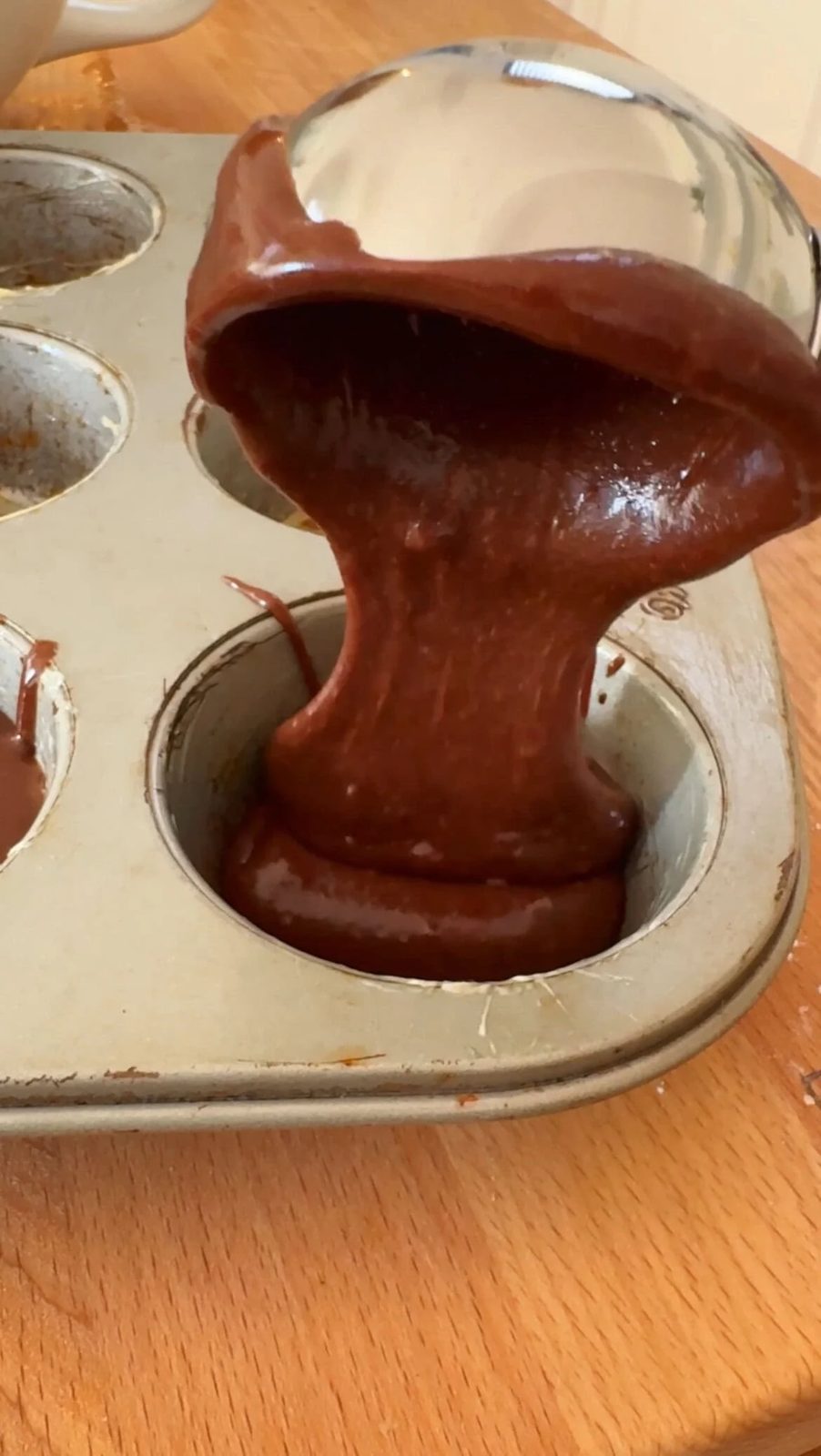 Filling muffin tin with brownie bite batter.