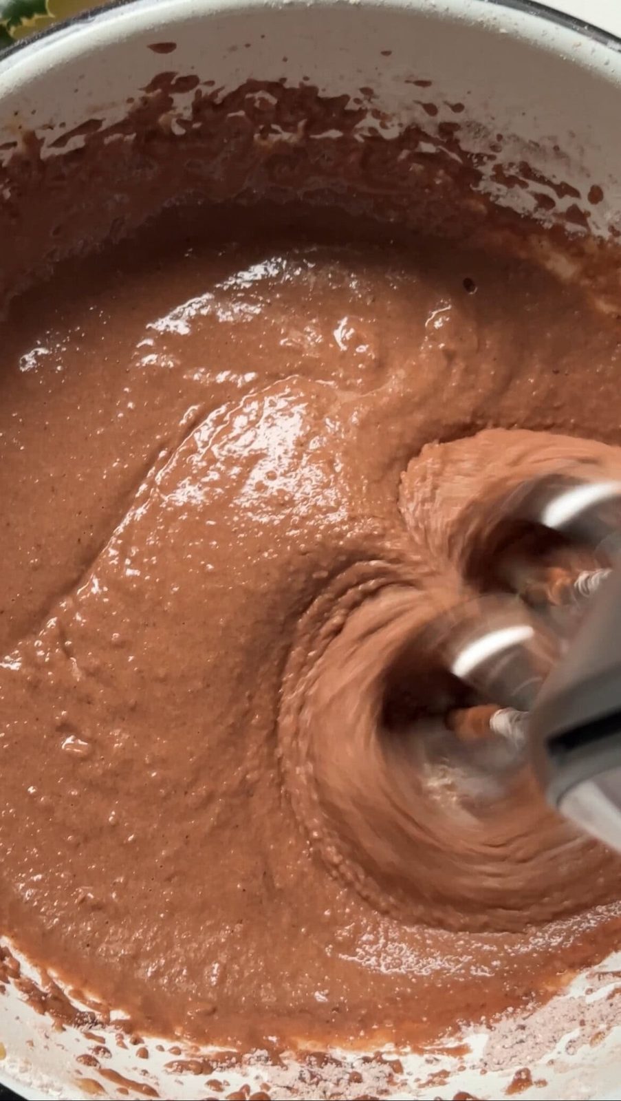 Beating the eggs, cocoa, and flour together.