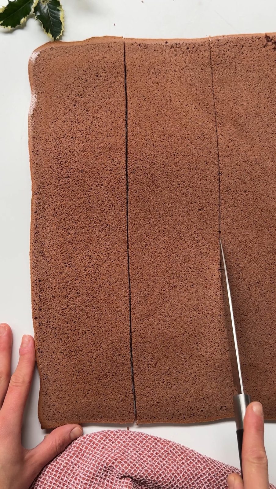 Slicing the yule log sponge into three pieces.