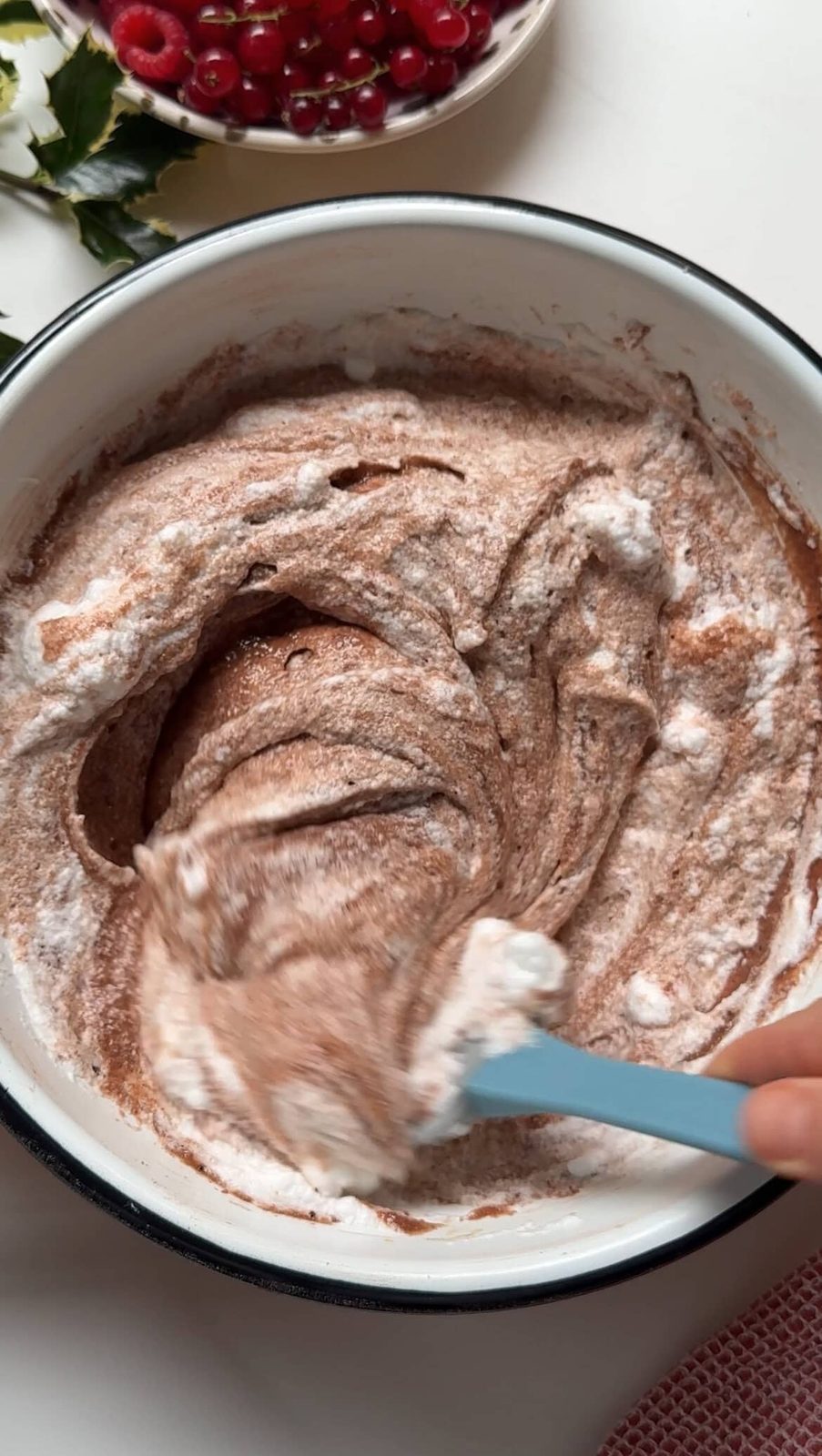 Folding egg whites into the chocolate batter.