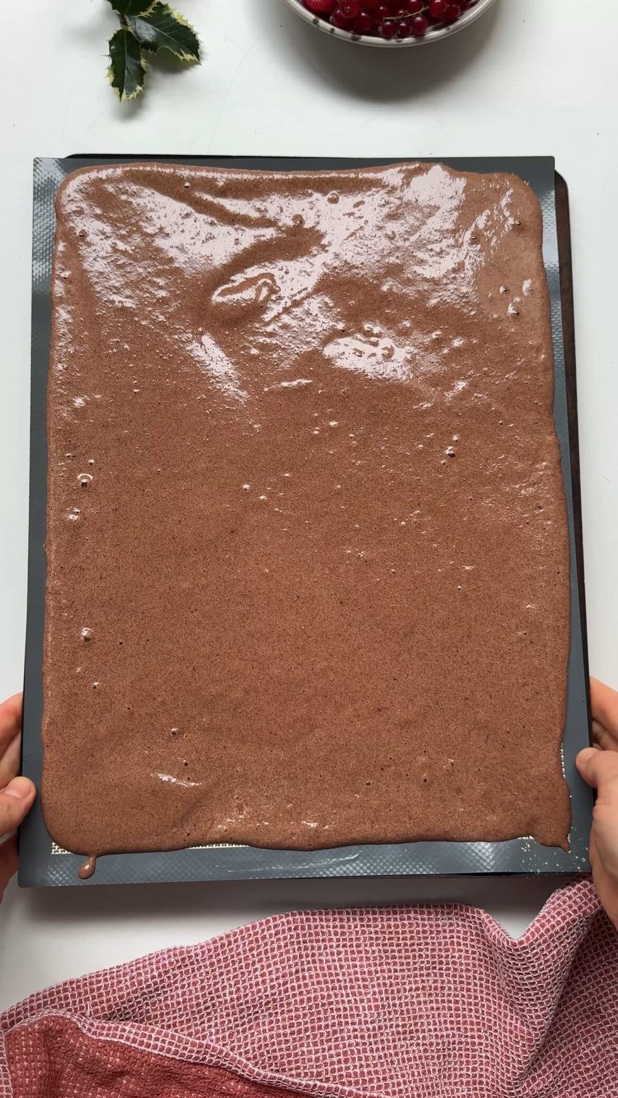 spreading the batter on a baking sheet to make yule log cake.