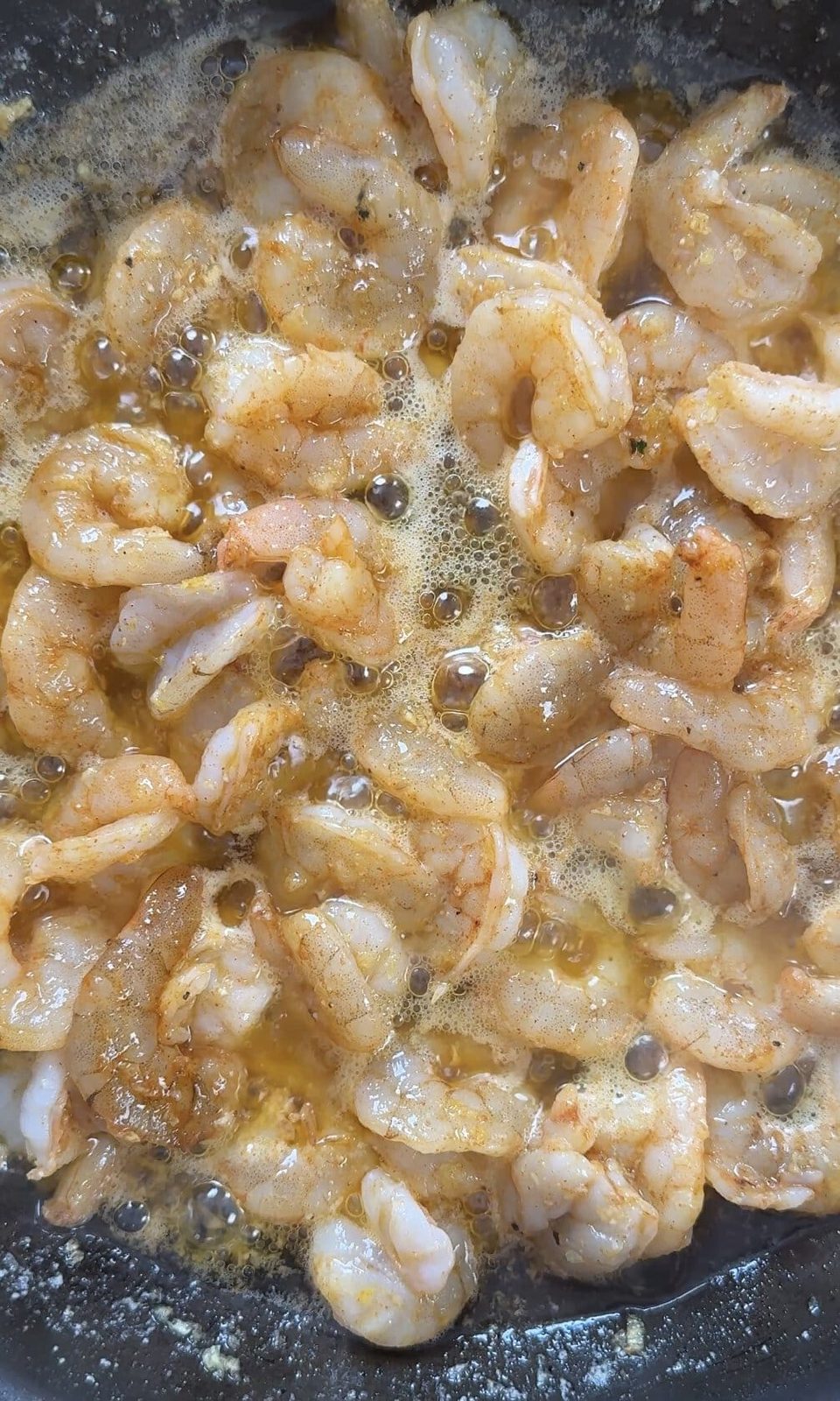 Frying buttered garlic prawns.