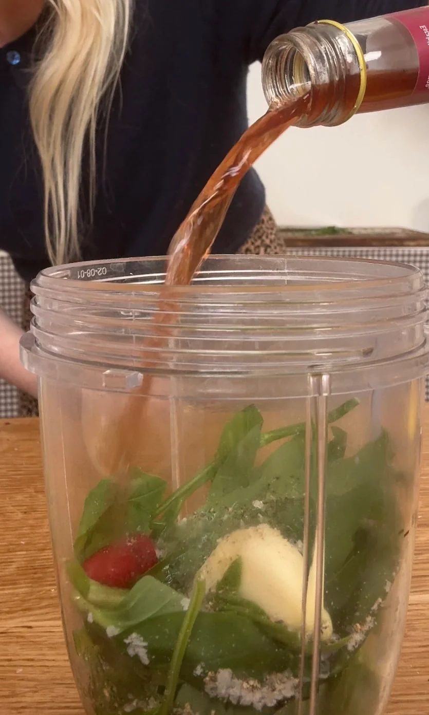 Adding red wine vinegar to sauce in blender.