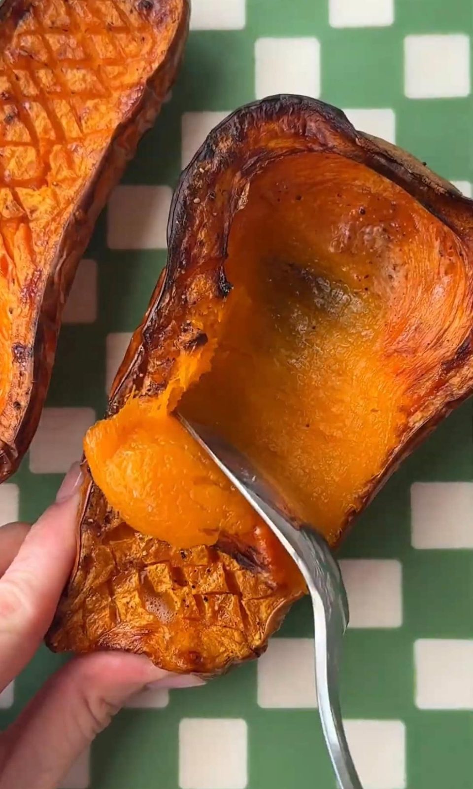 scooping butternut squash out of the skin.