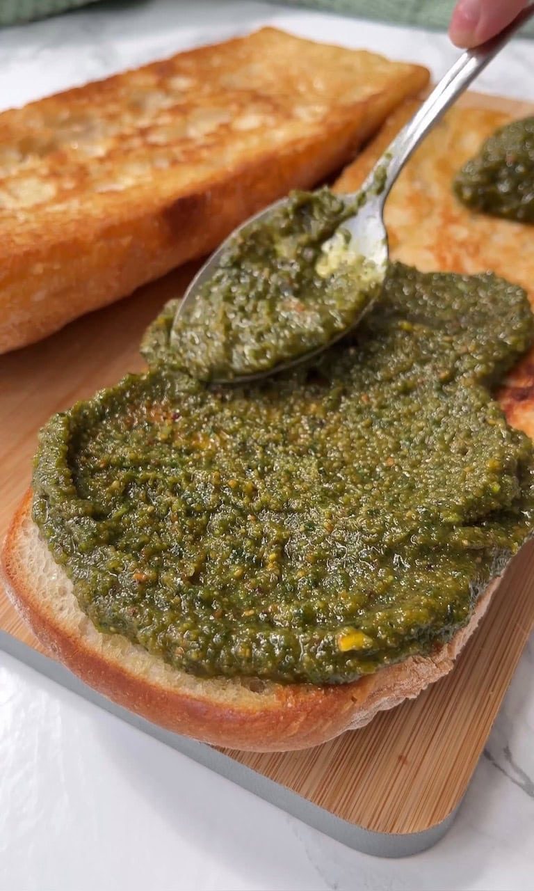 smoothing pesto on ciabatta.