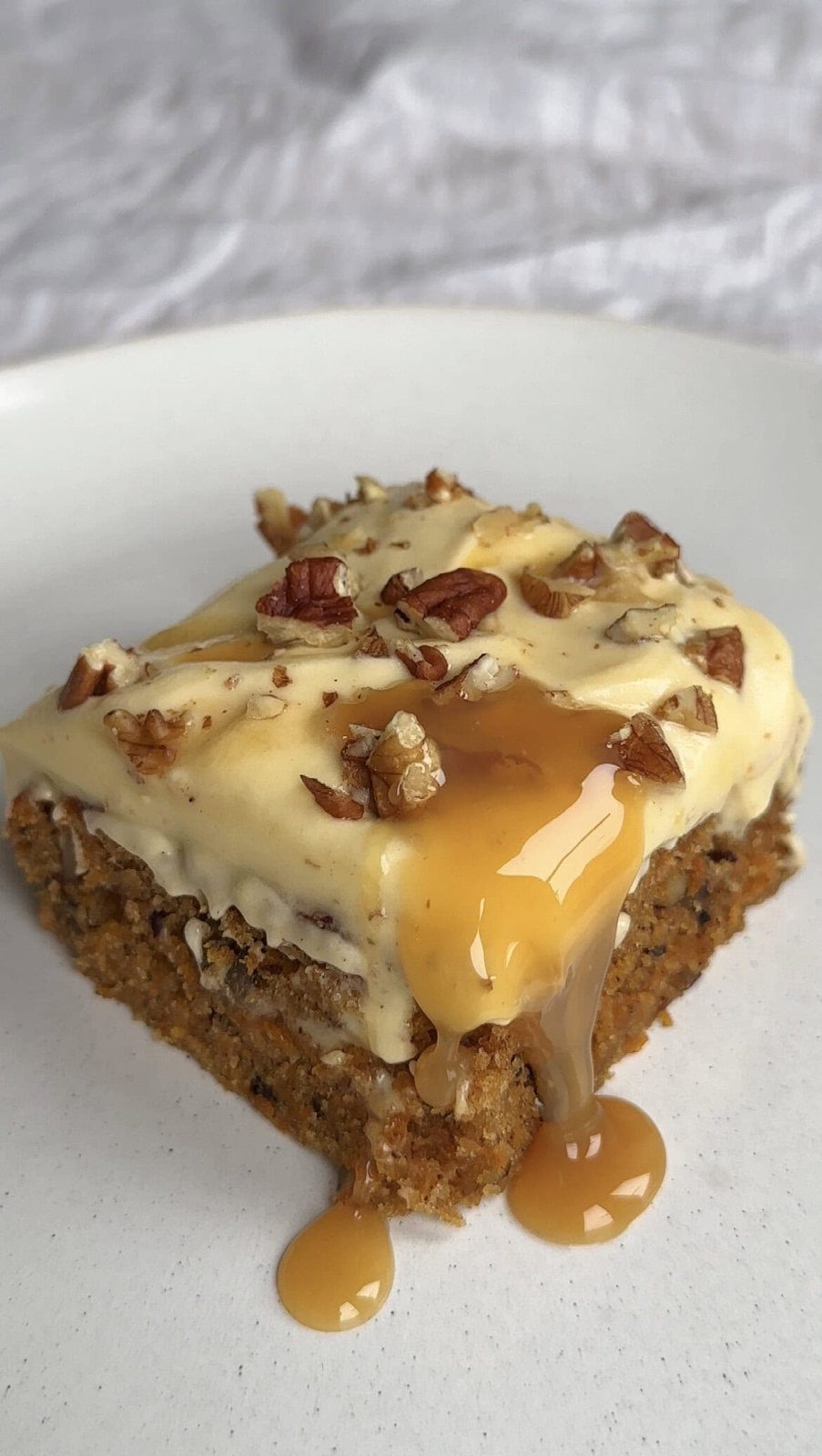 carrot cake tray bake. slice on a white plate.