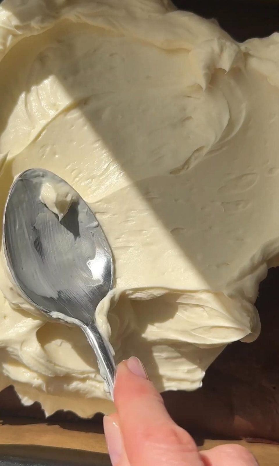 smoothing cheesecake topping onto the brownie.