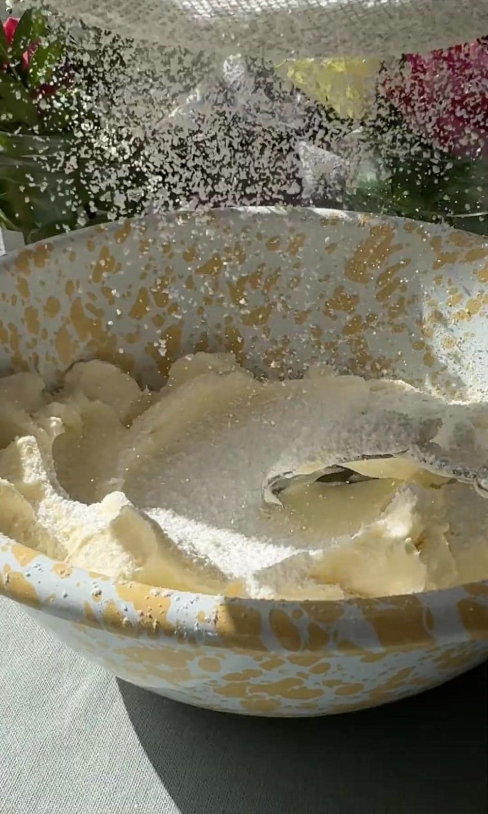 adding icing sugar to cheesecake mixture.