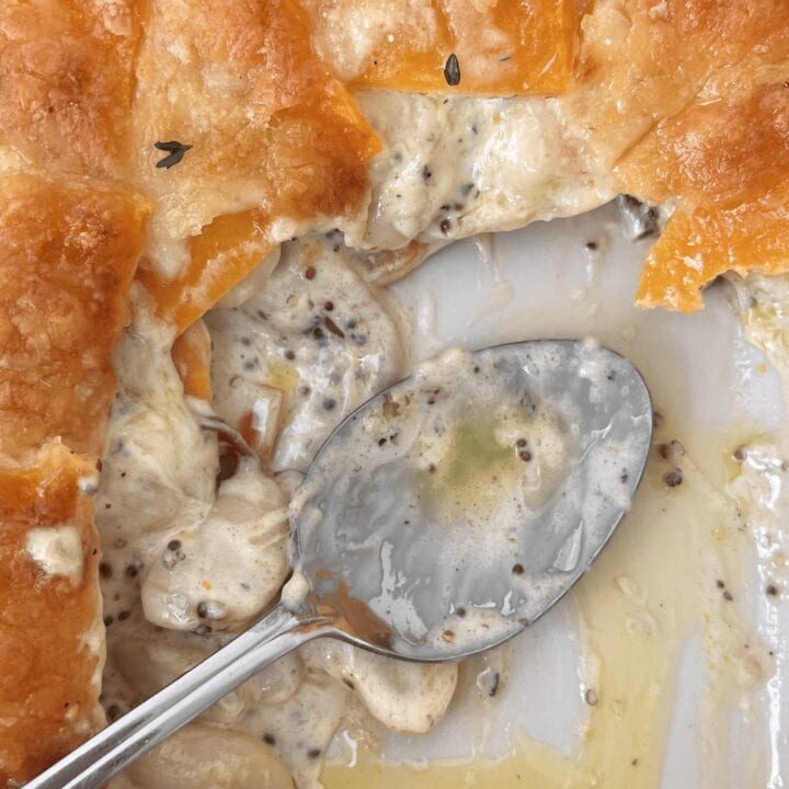 Butternut squash gratin in dish with serving spoon.